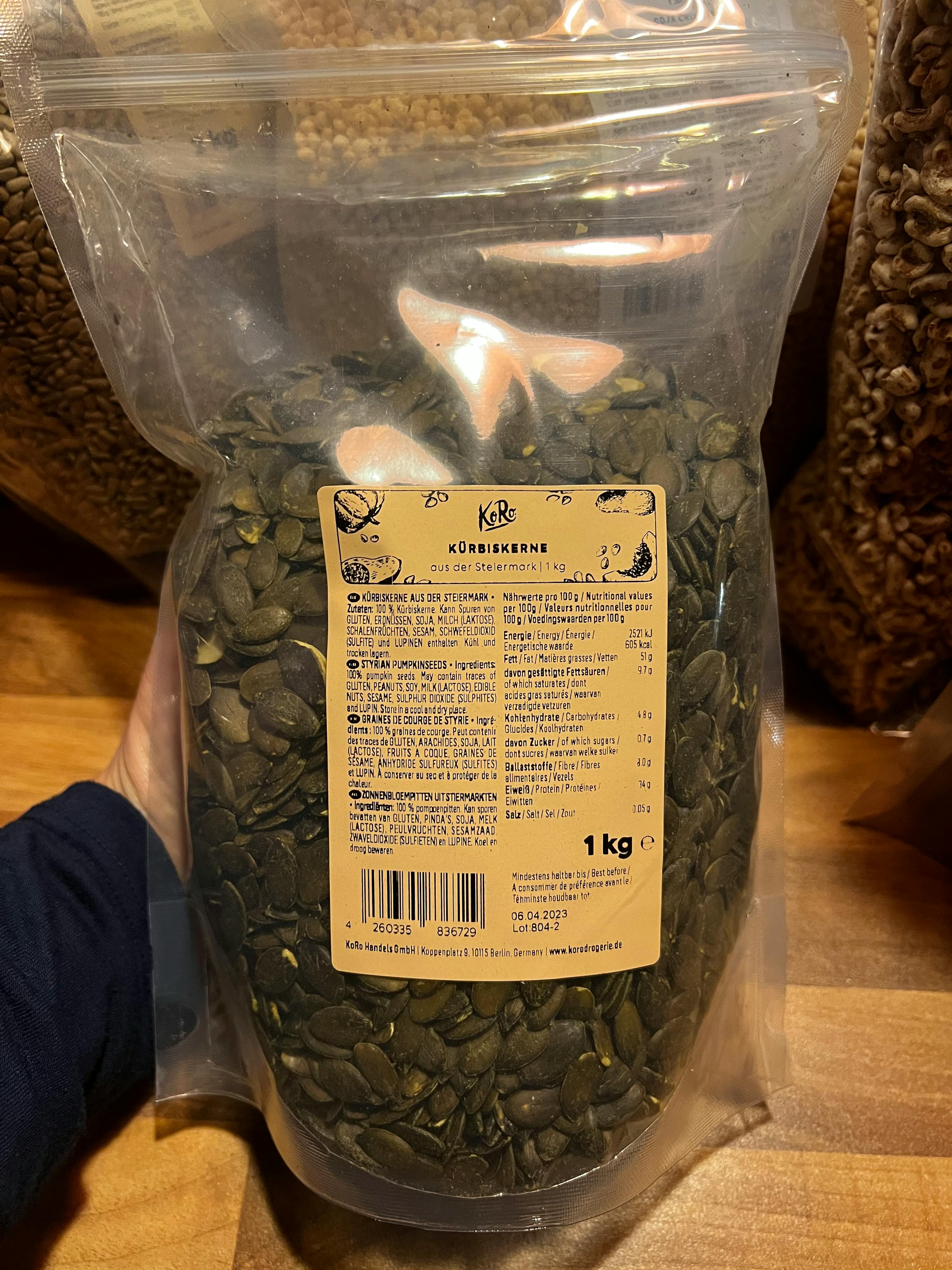 a person is holding a bag of pumpkin seeds