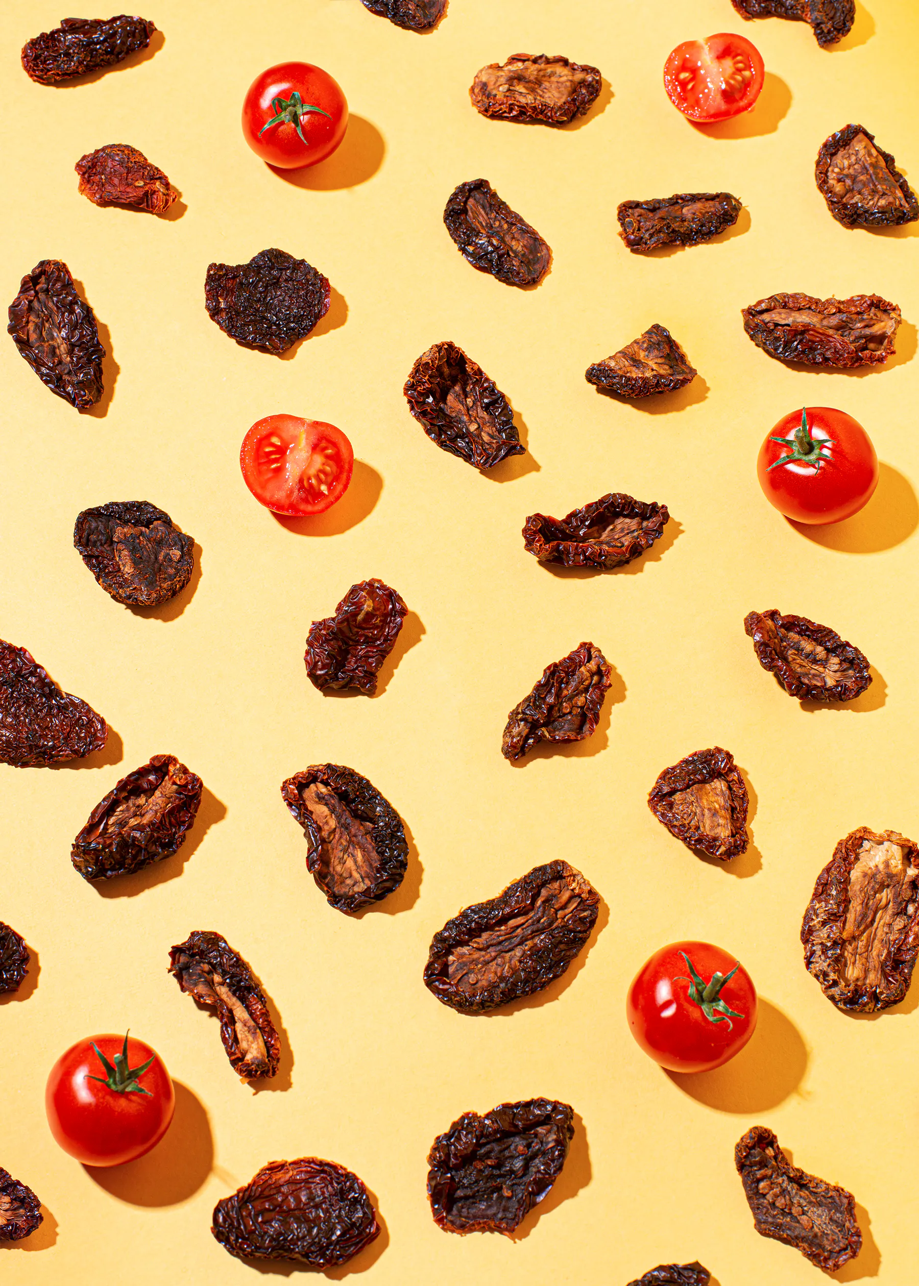 dried tomatoes and tomatoes on a yellow background