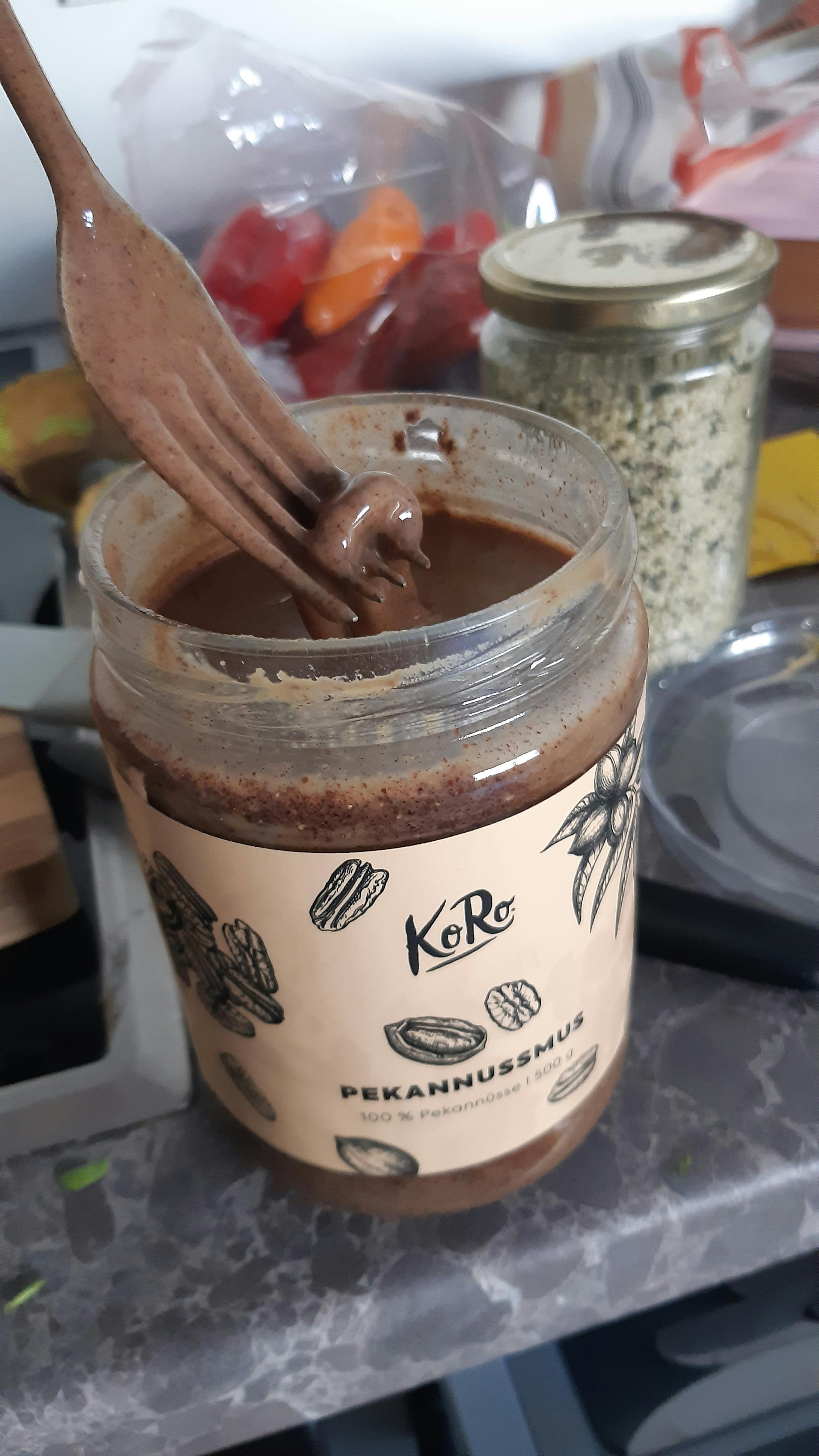 a jar of pecannussmus has a spoon in it