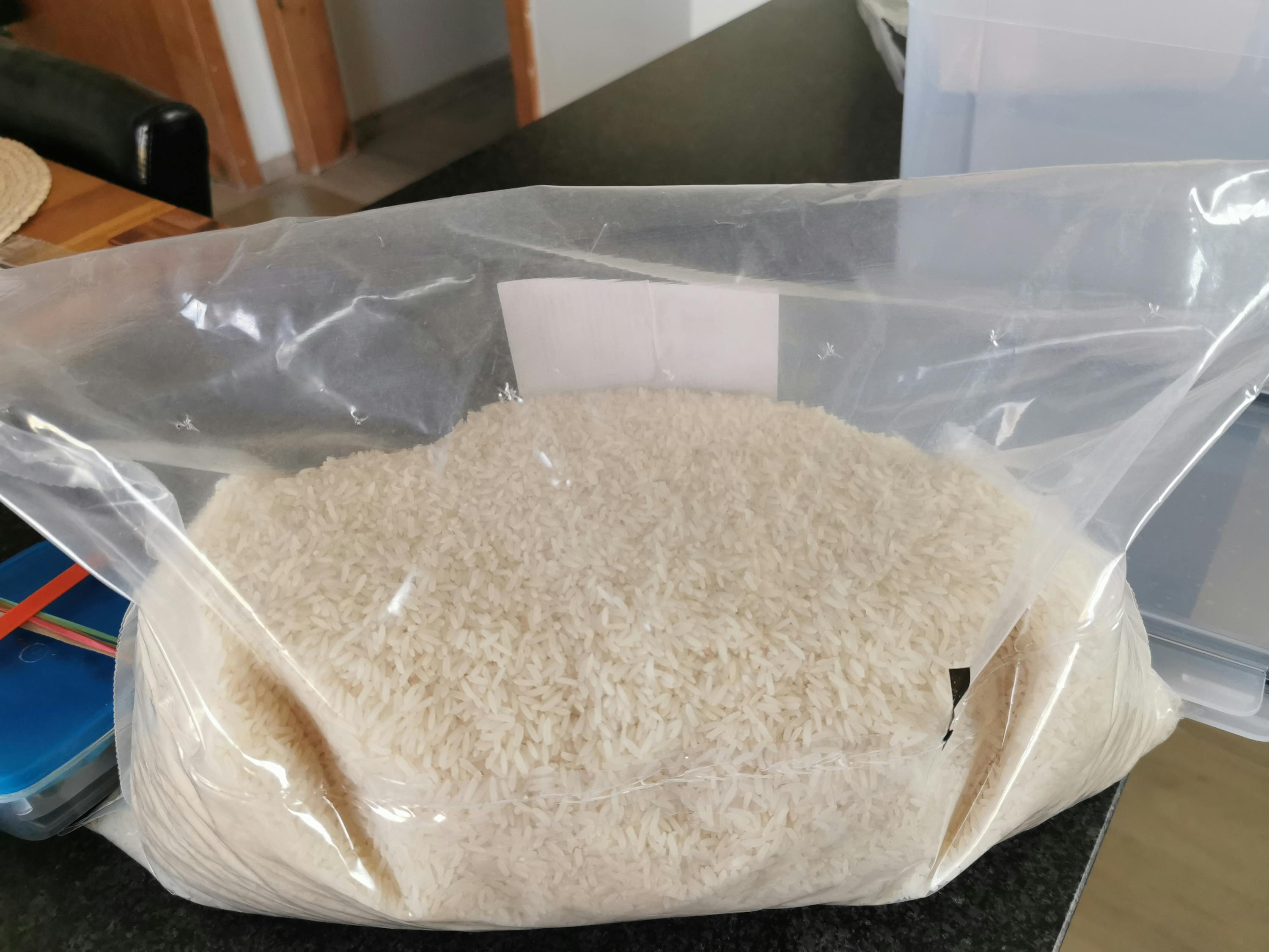 un sac en plastique rempli de riz blanc sur une table