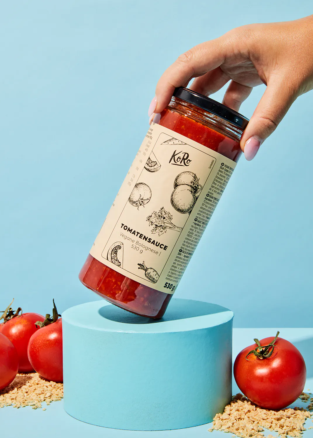 Eine Person hält ein Glas Tomatensauce in der Hand