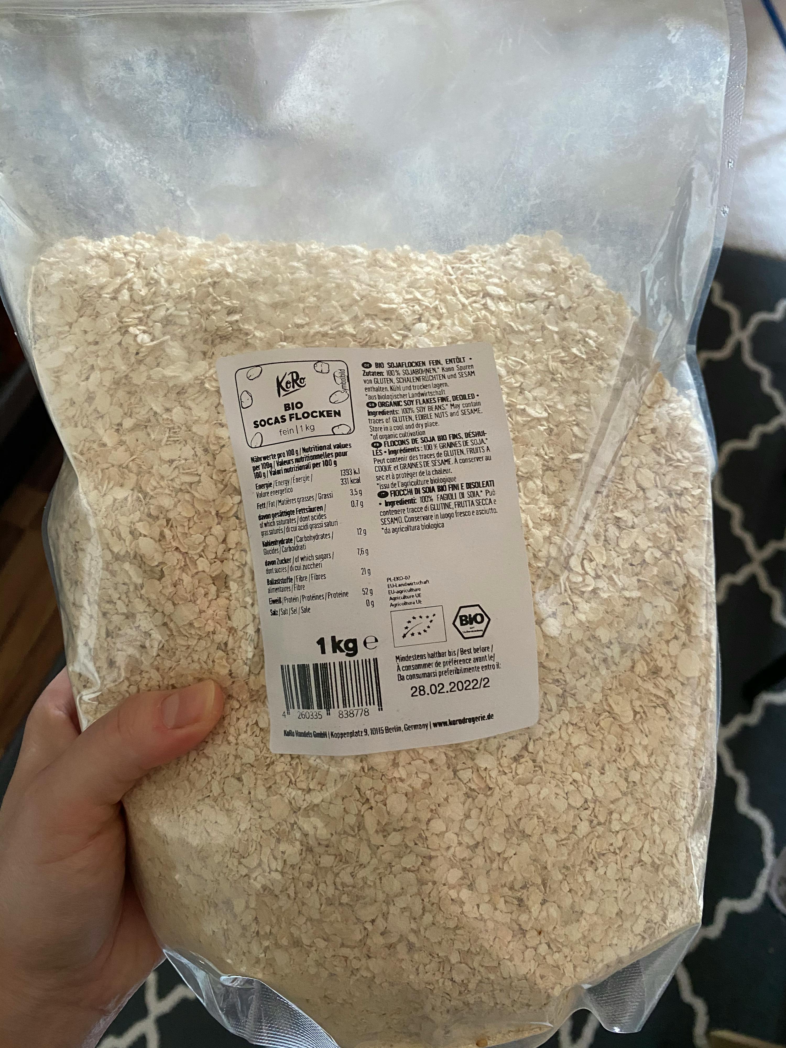 une personne tient un sac de flocons d' avoine de 1kg