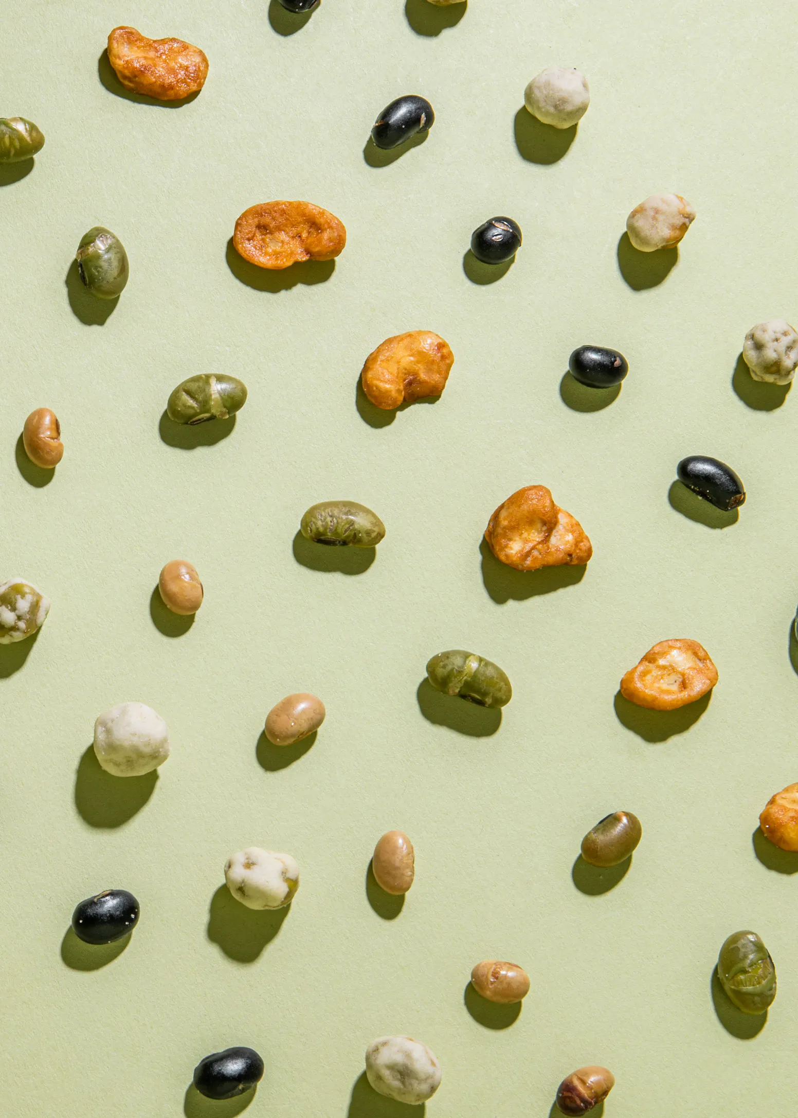 un tas de différents types de noix et de haricots sur fond vert