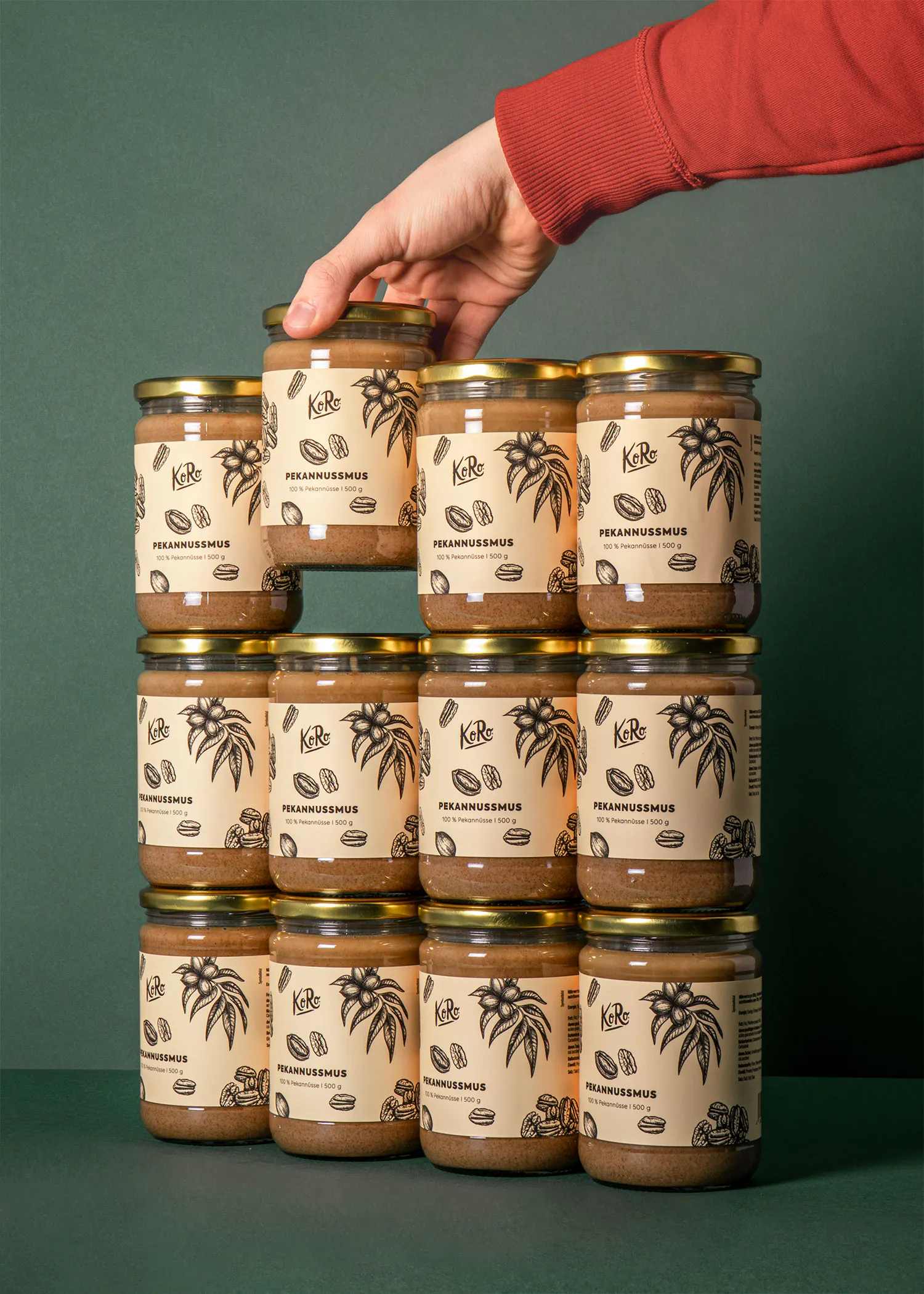 a person is holding a jar of pecan butter