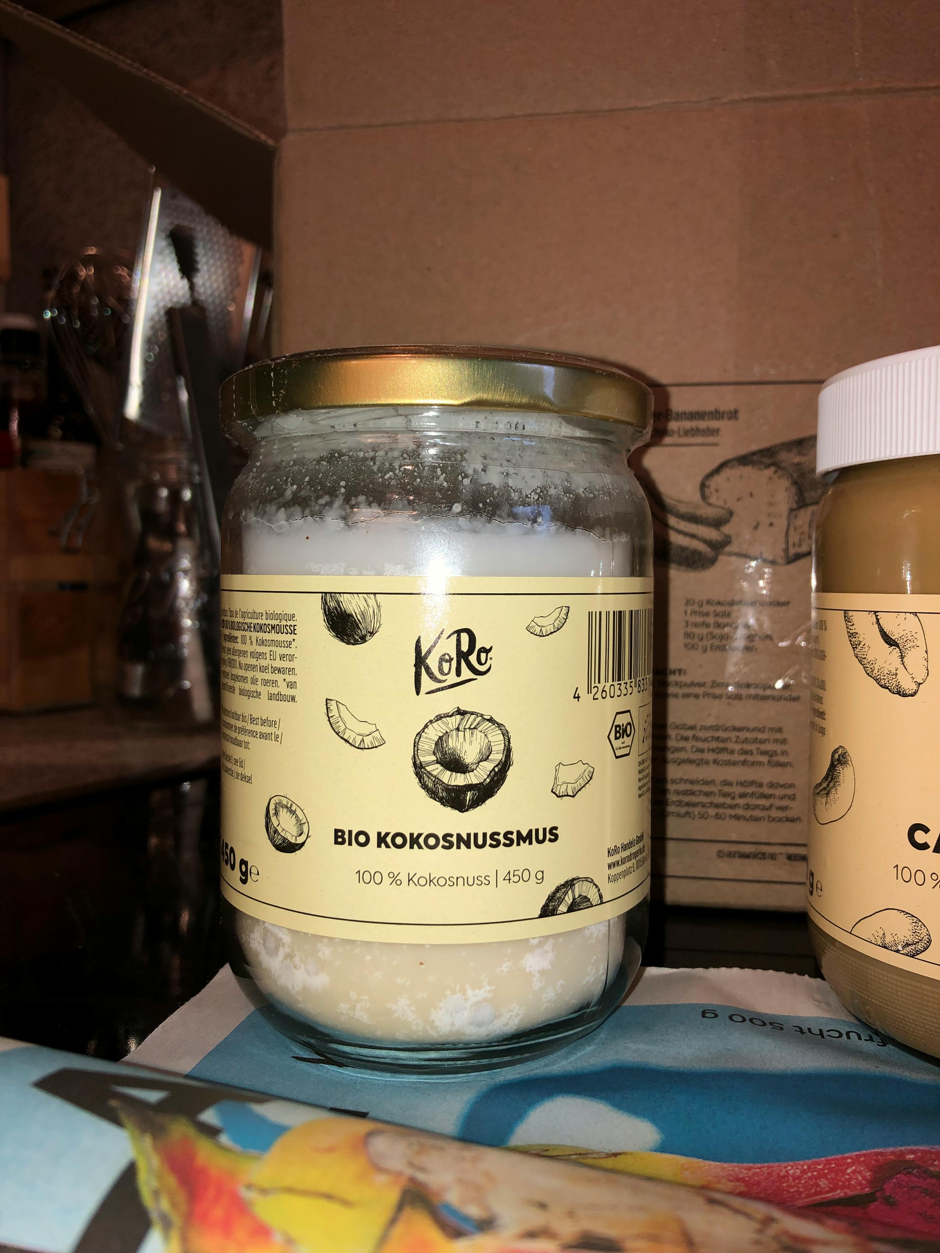 a jar of bio kokosnussmus sits next to a jar of peanut butter