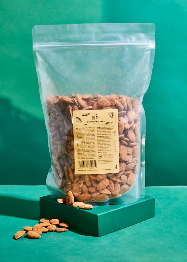 un sac d' amandes est assis sur une table verte