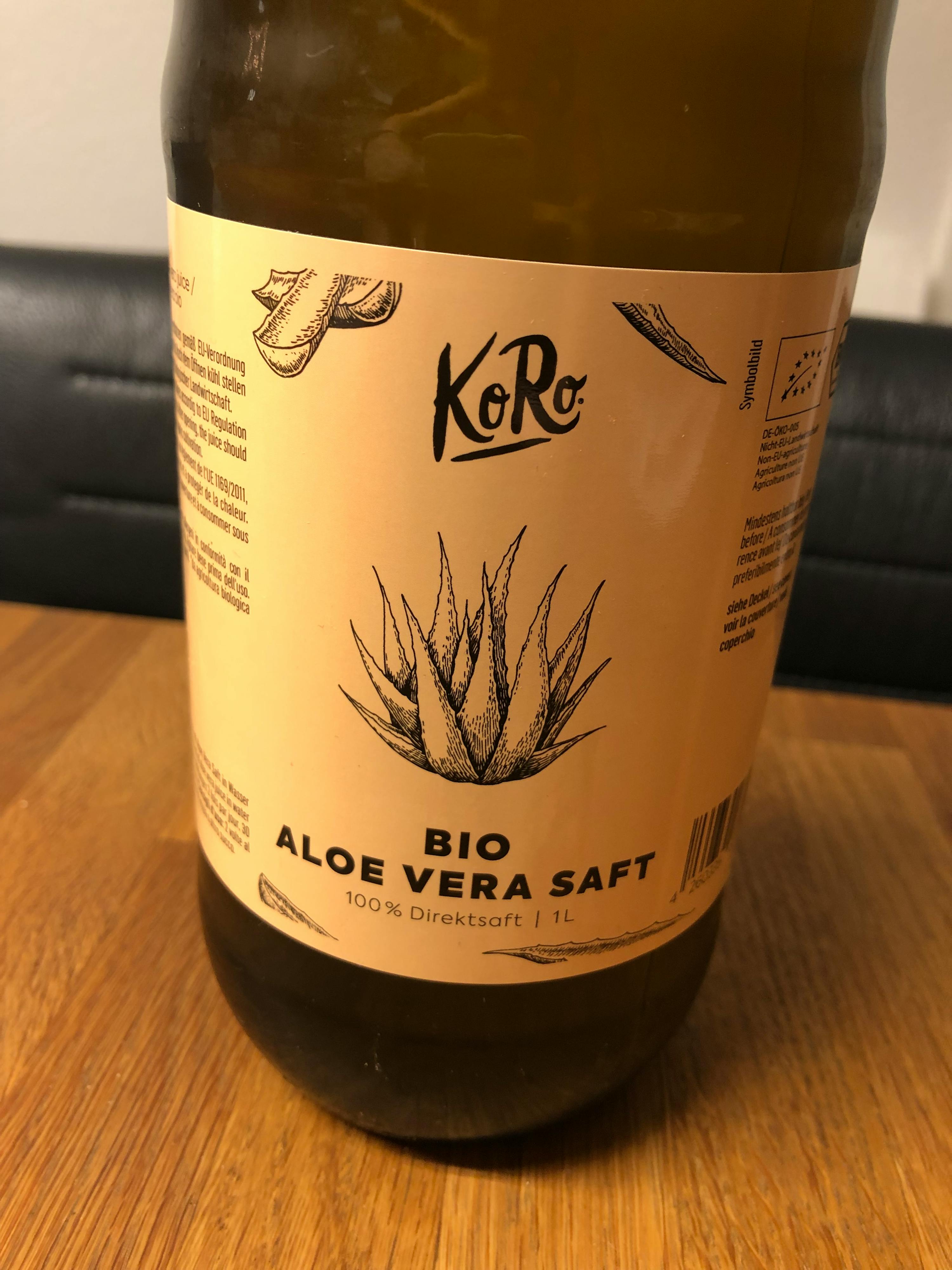 une bouteille d' aloe vera bio est assise sur une table en bois