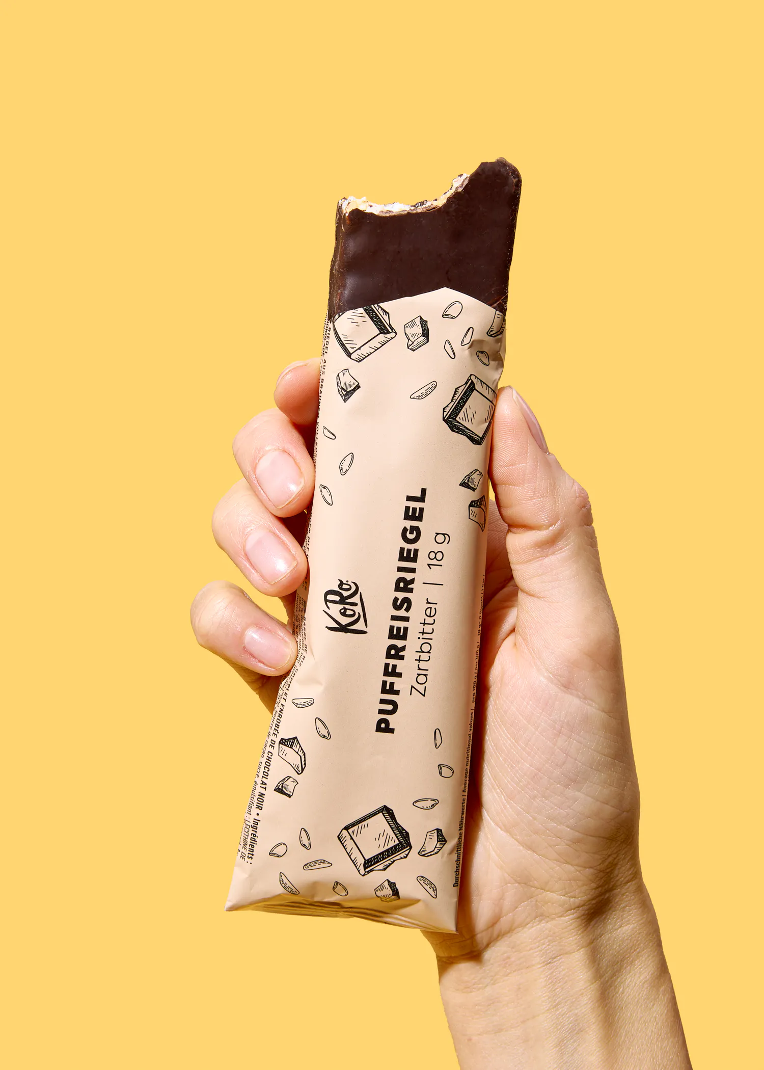 une main tient une barre de chocolat avec un morceau de chocolat à l' intérieur