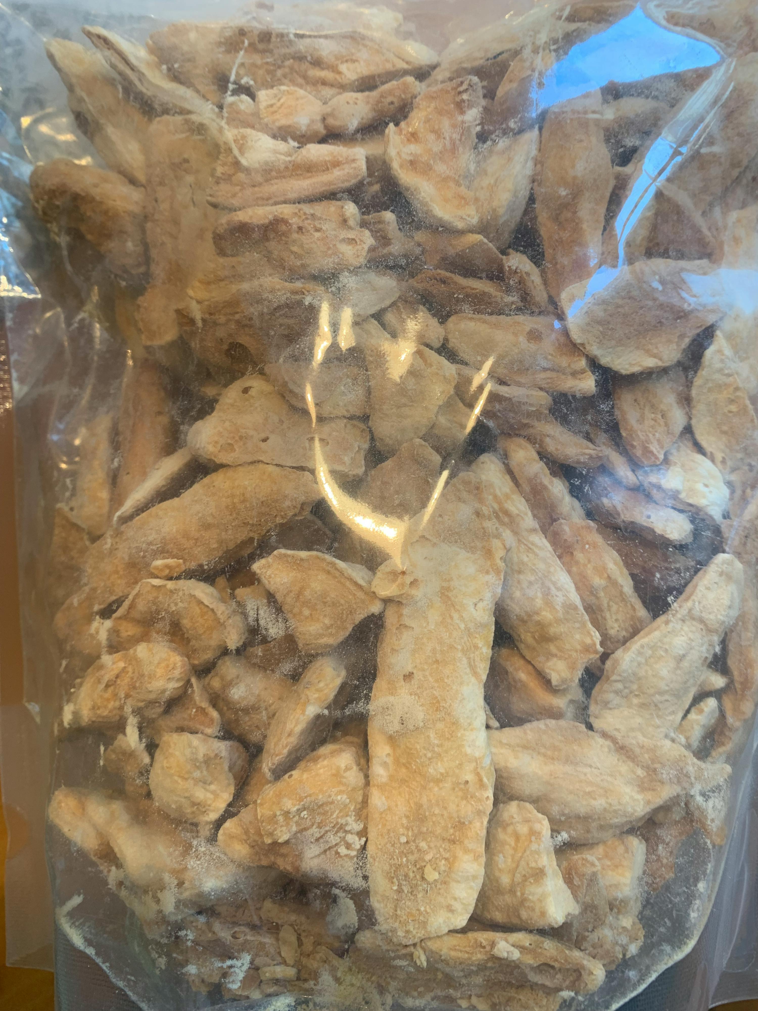 a plastic bag filled with pieces of bread is sitting on a table