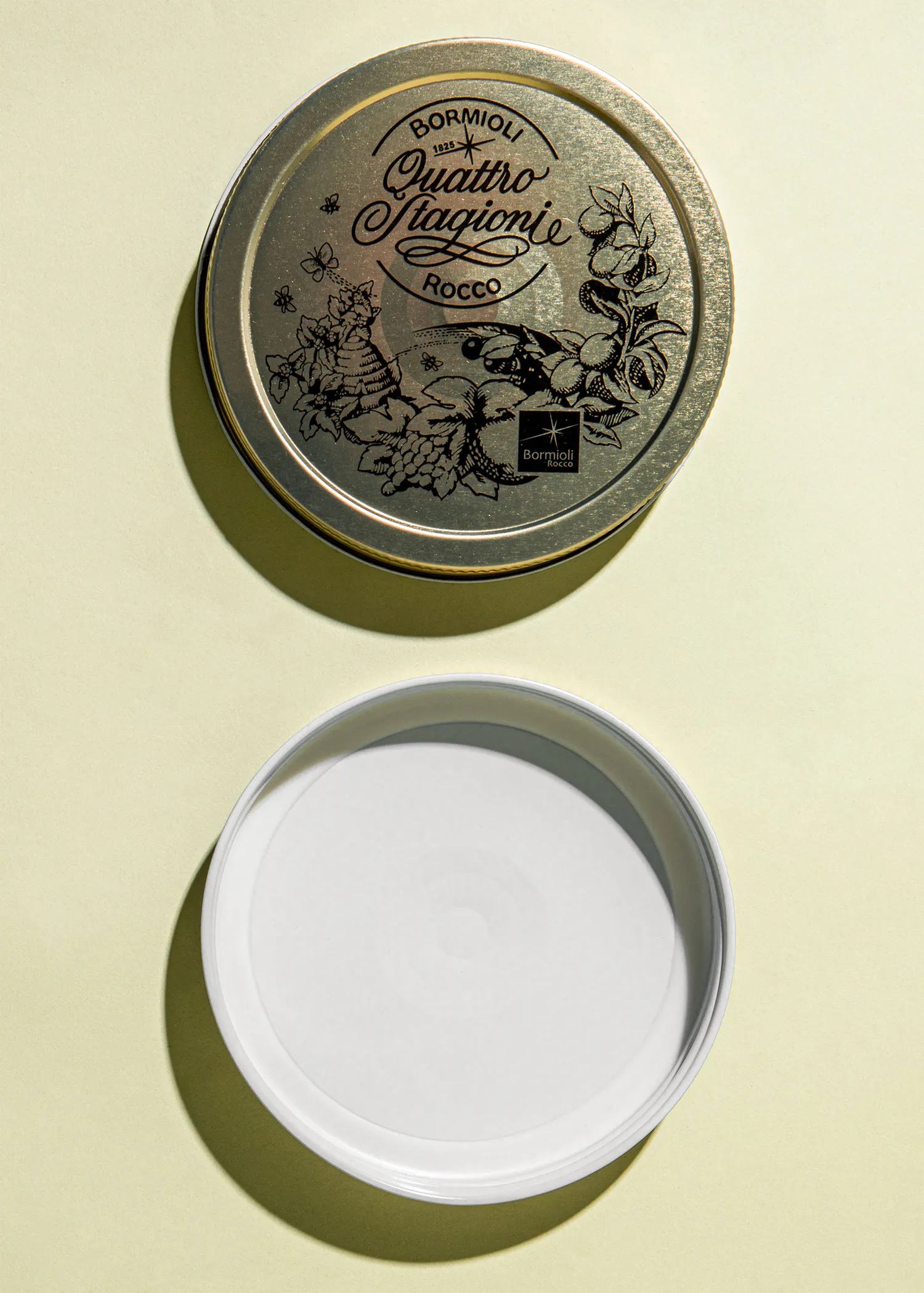 ein goldener Deckel mit der Aufschrift bormioli quattro stagionie rocco neben einem weißen Deckel