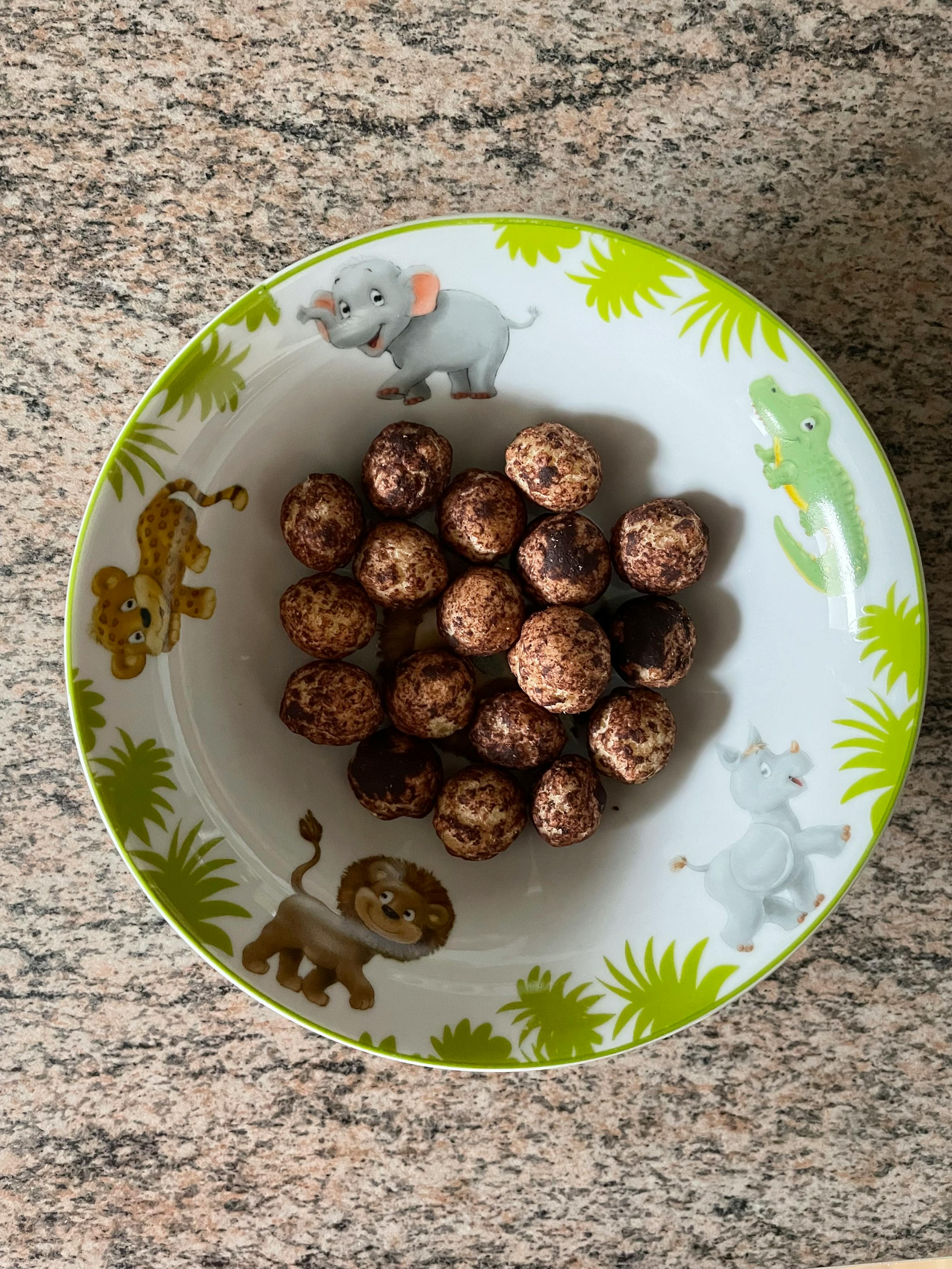 un bol vert et blanc avec des animaux dessus