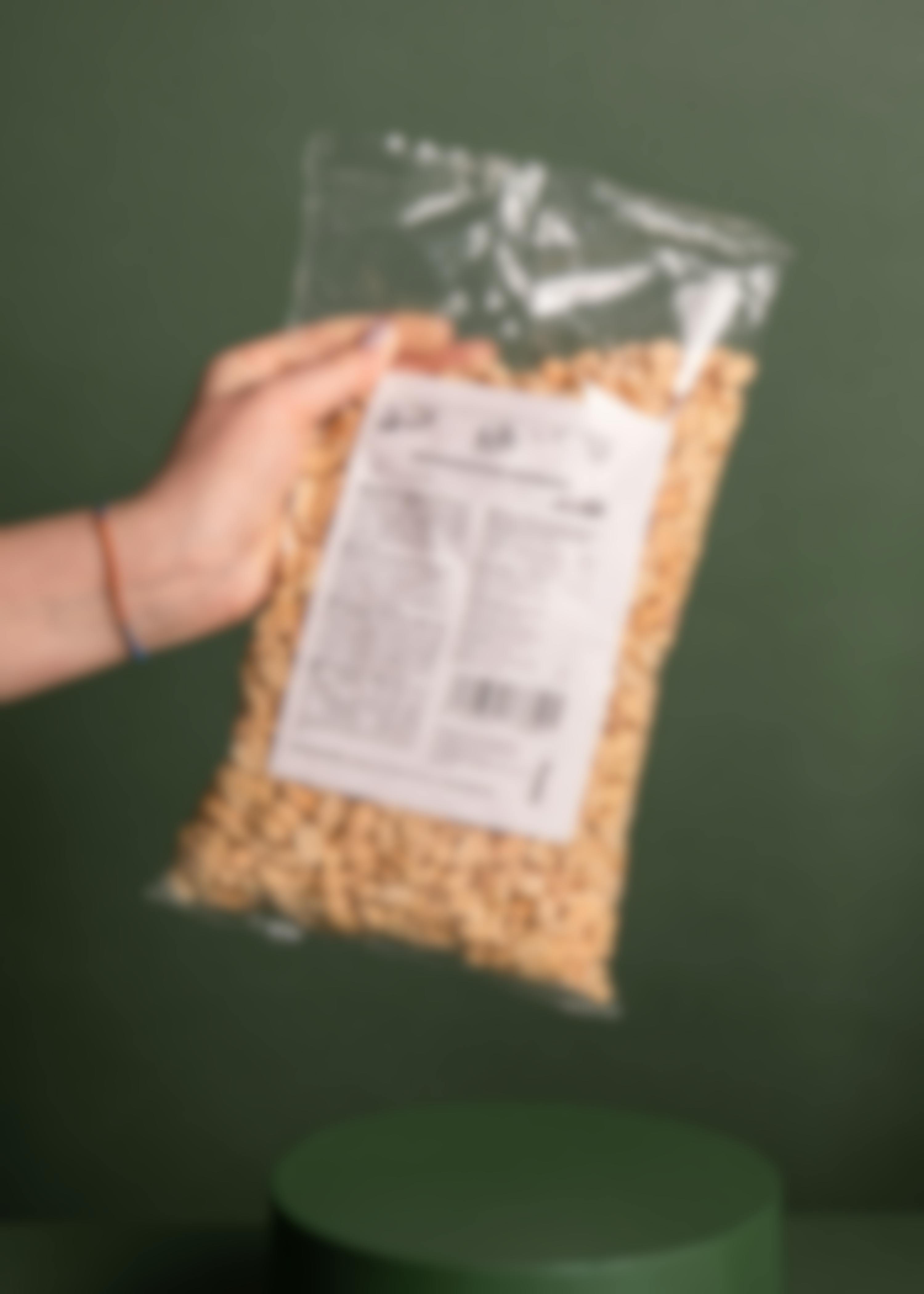 Hand hält Großpackung geröstete Erdnüsse mit Kalorien Angabe 
