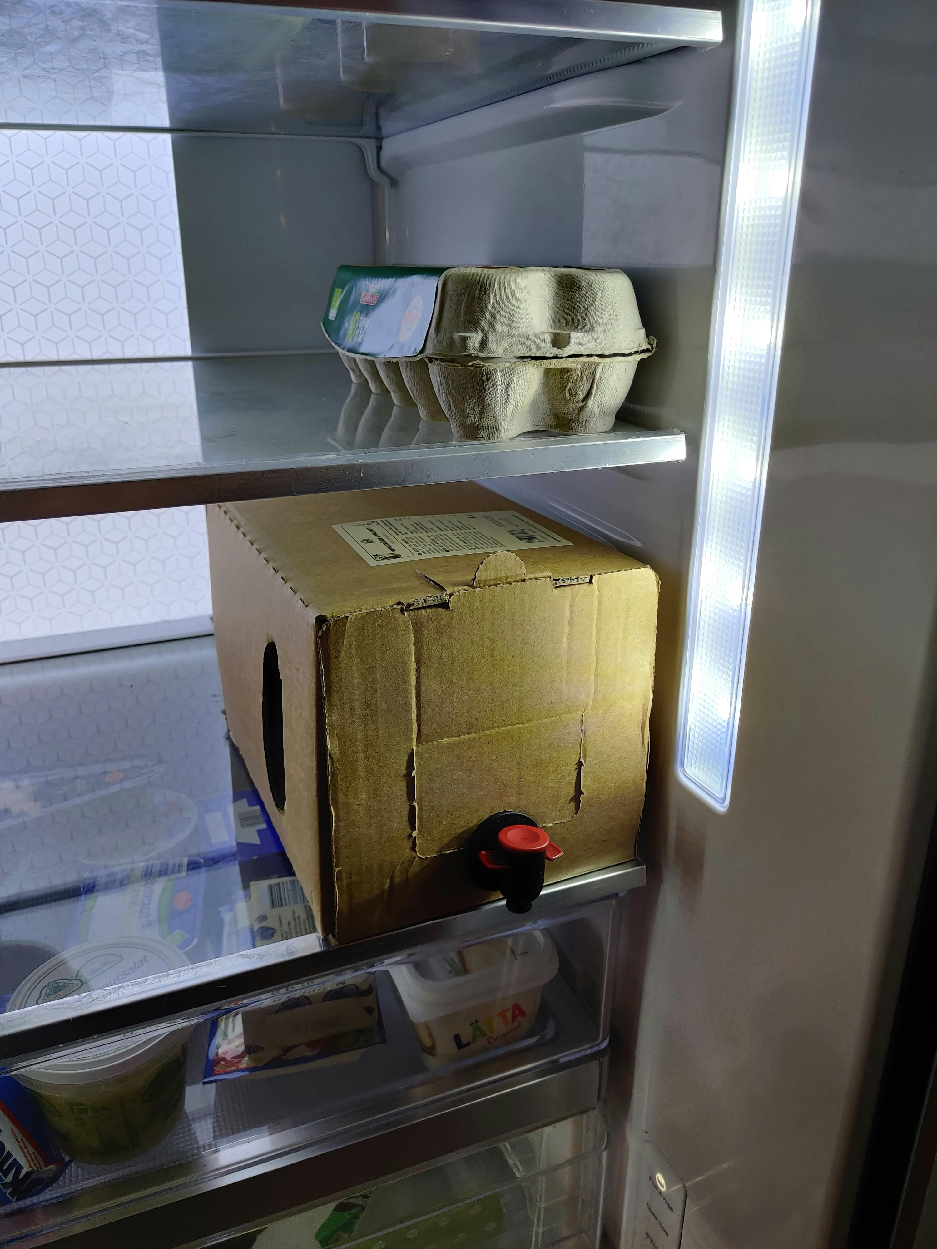 un réfrigérateur avec un carton d' œufs à côté d' une boîte en carton