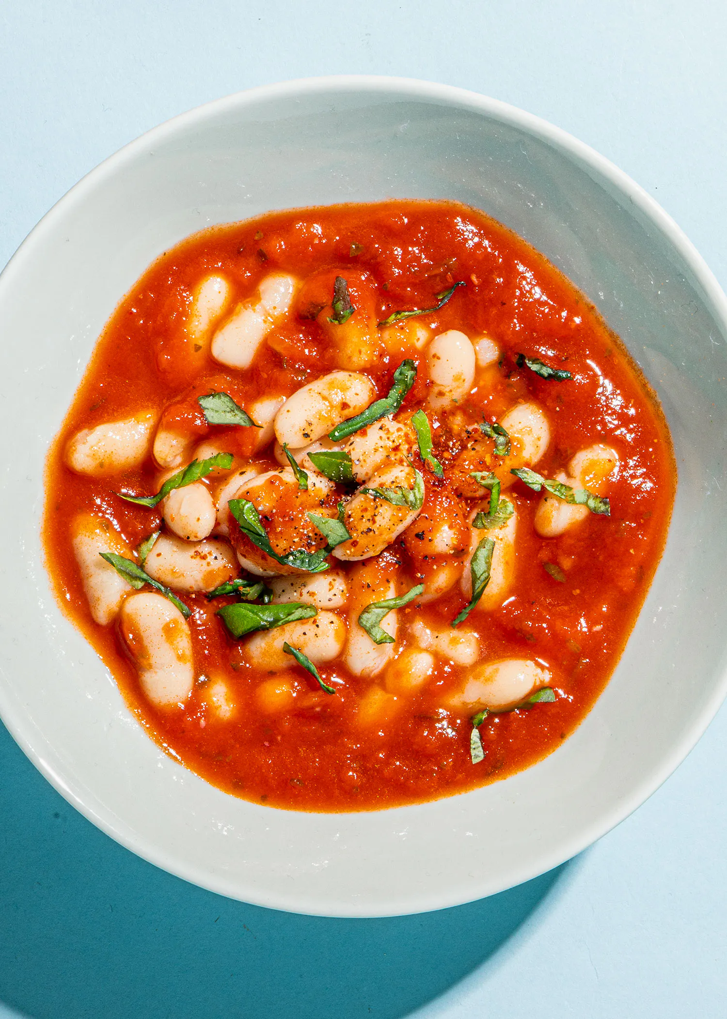 un bol blanc rempli de haricots et de sauce tomate