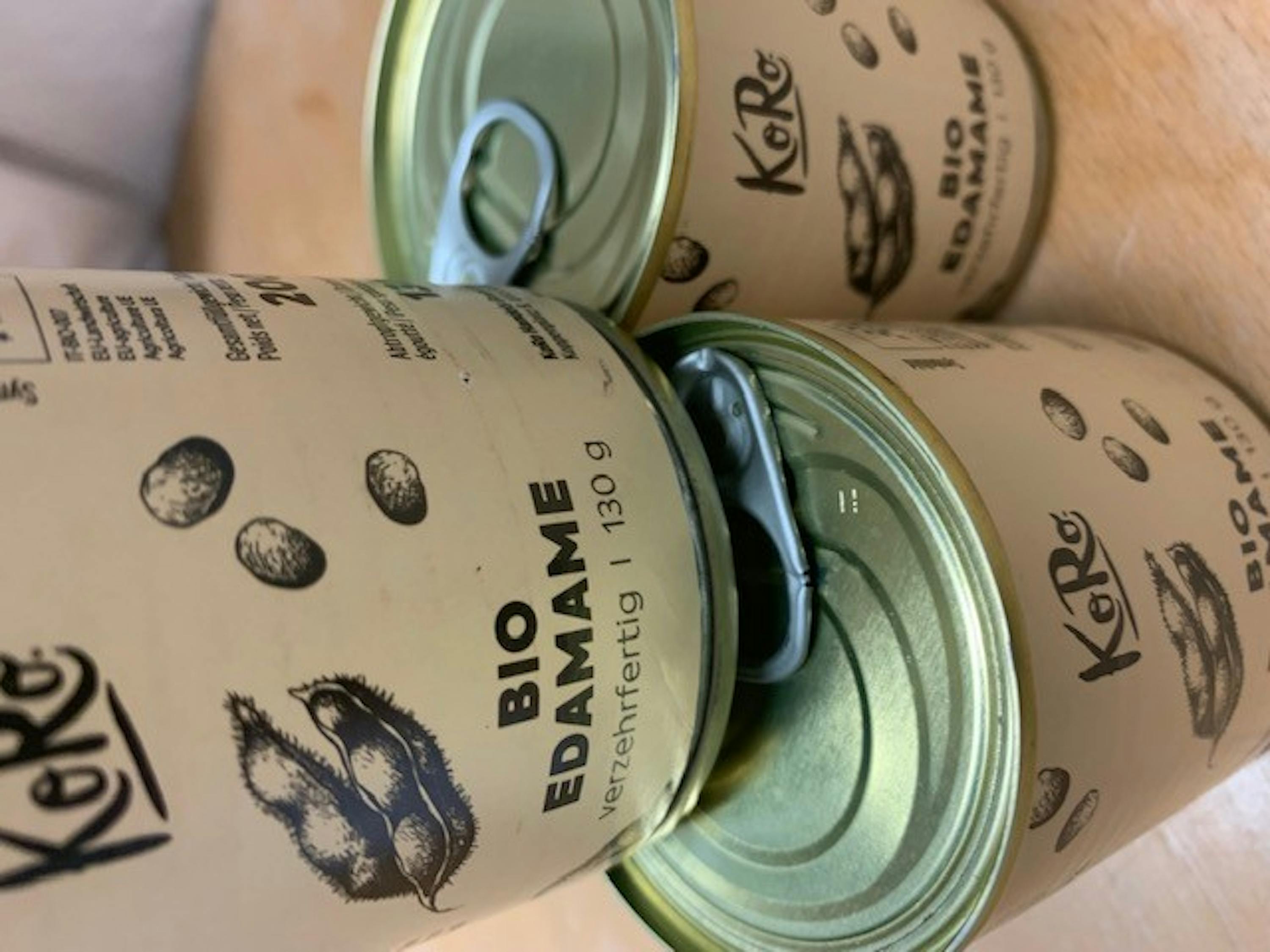 three cans of bio edamame beans are stacked on top of each other