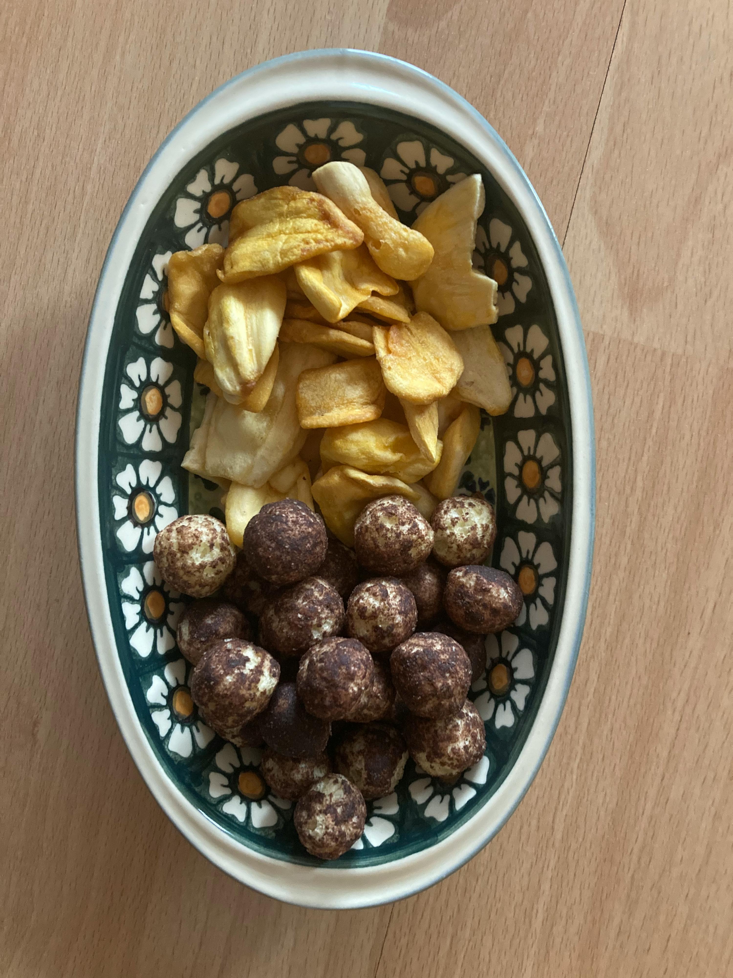 un bol avec un motif de fleurs contient des chips et des bonbons