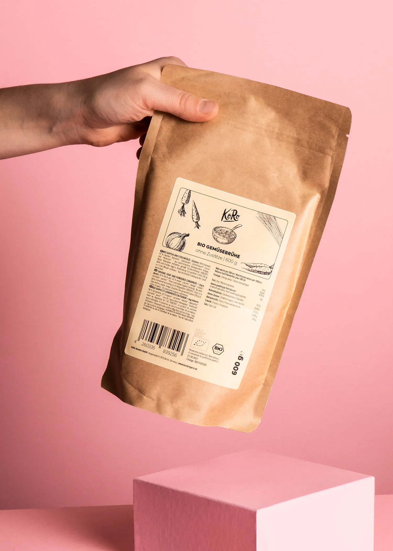 eine hand hält einen braunen beutel mit einem weißen etikett mit der marke kelle