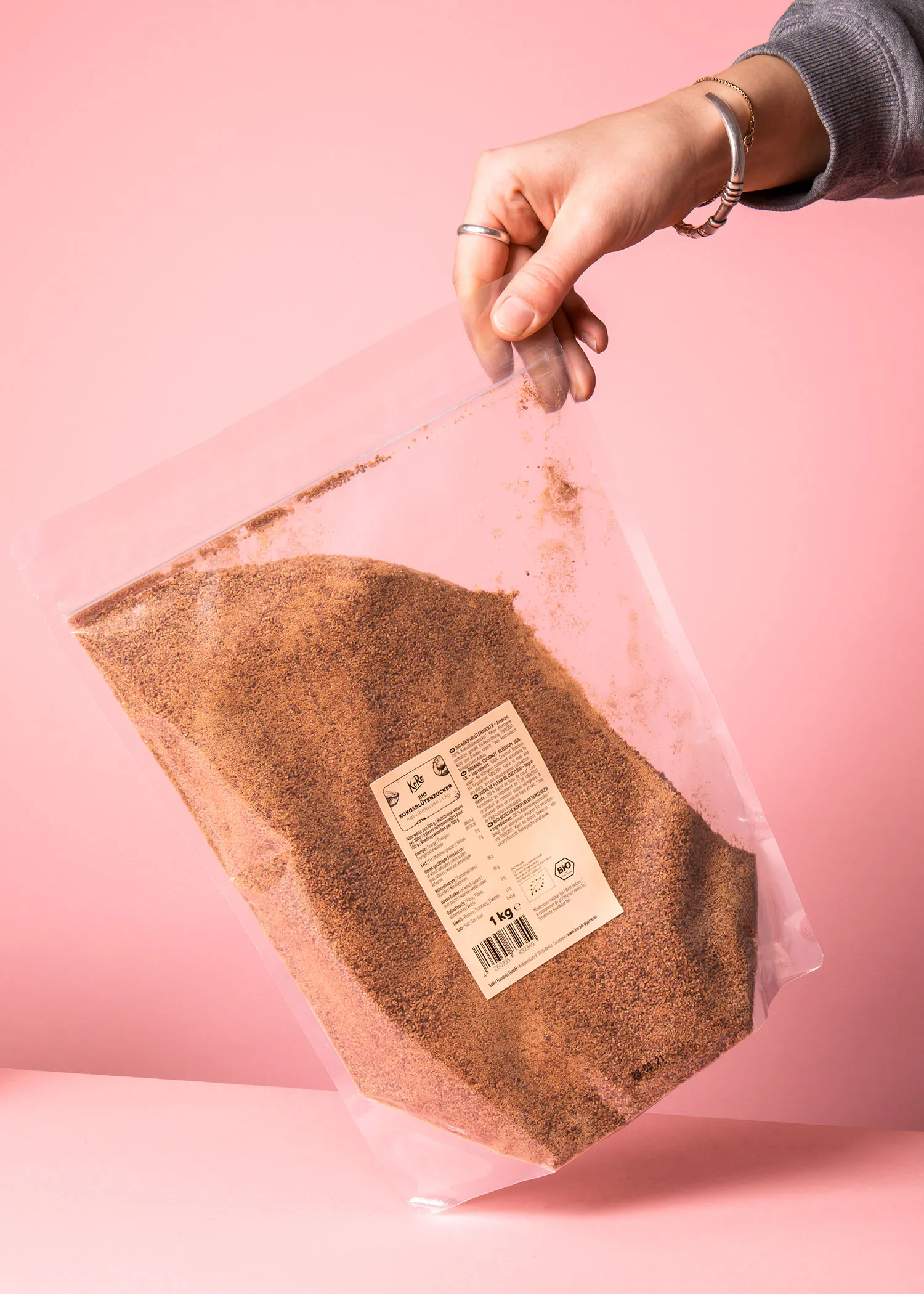 a person is holding a bag of brown powder that says 1 kg on it