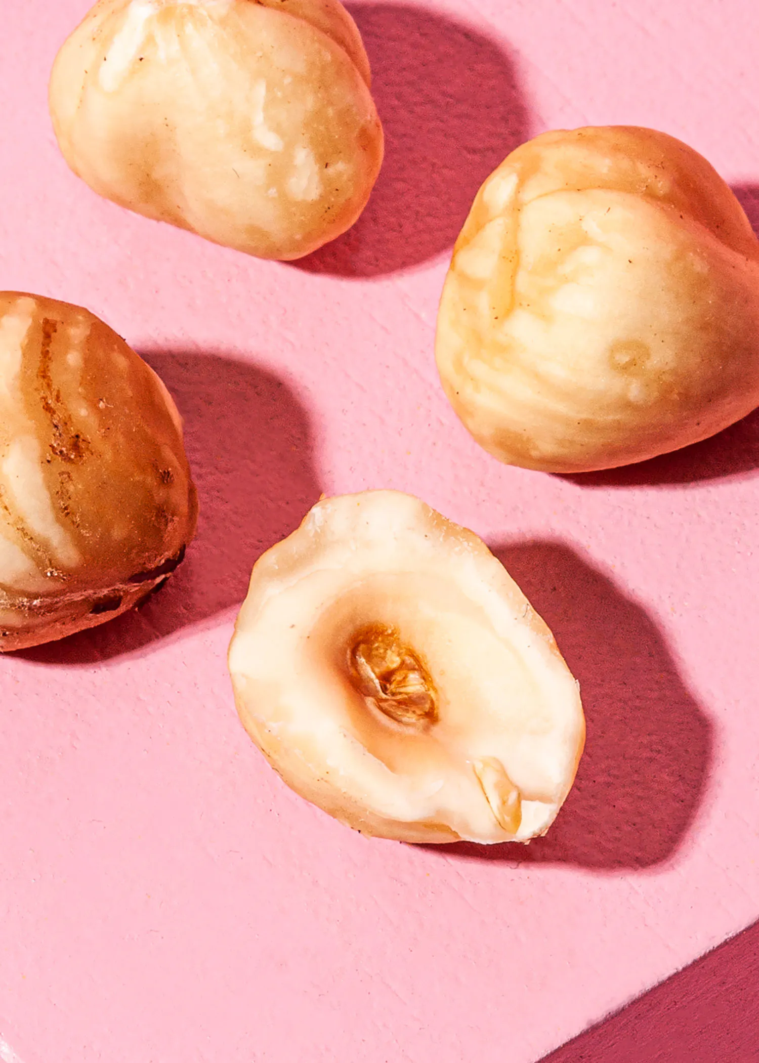 un gros plan d' une noix sur une surface rose