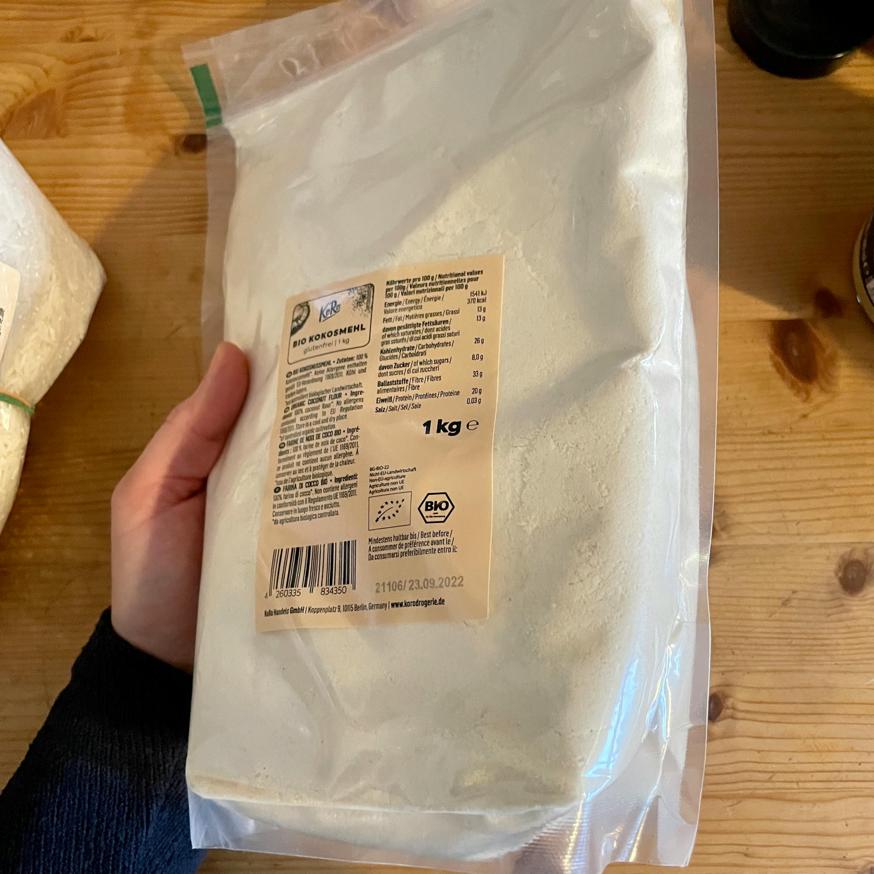 a person is holding a bag of bio kokosmehl