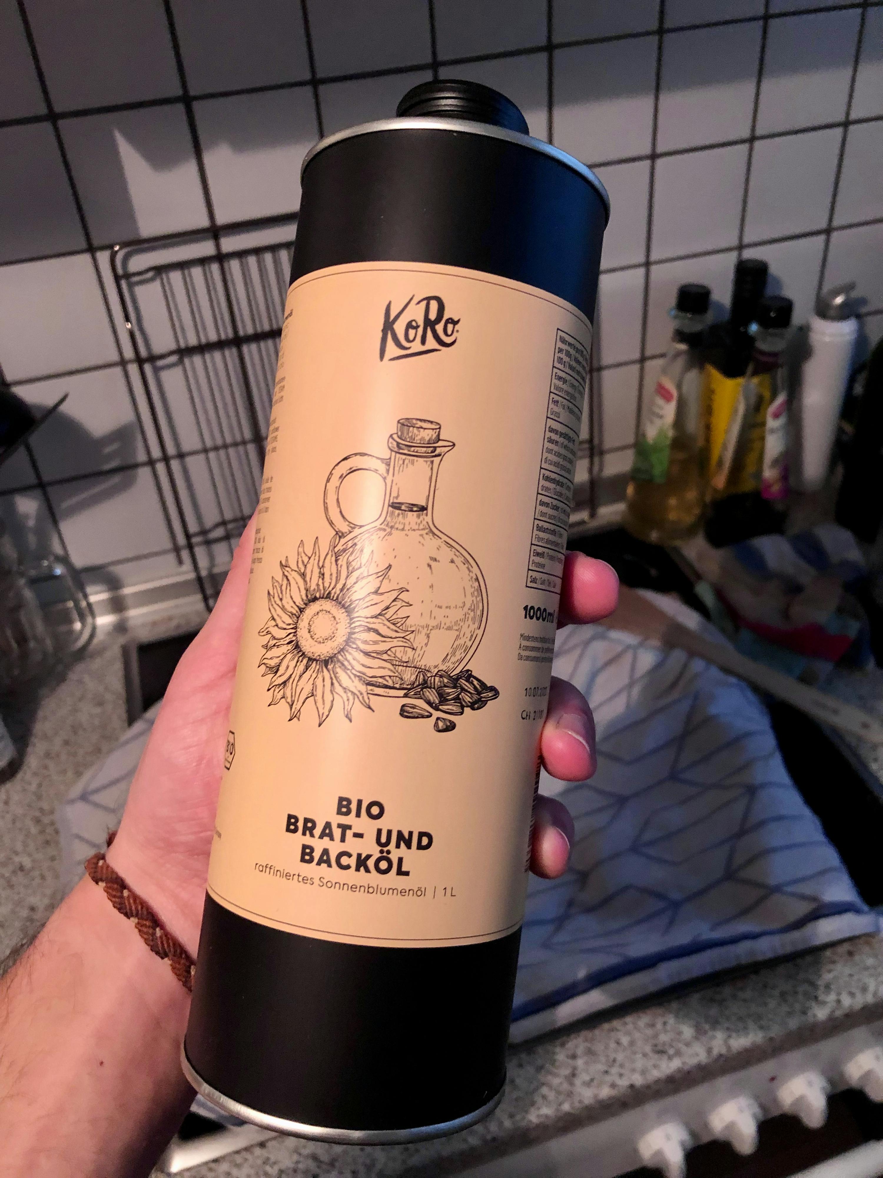 una persona tiene in mano una bottiglia di olio di girasole bio