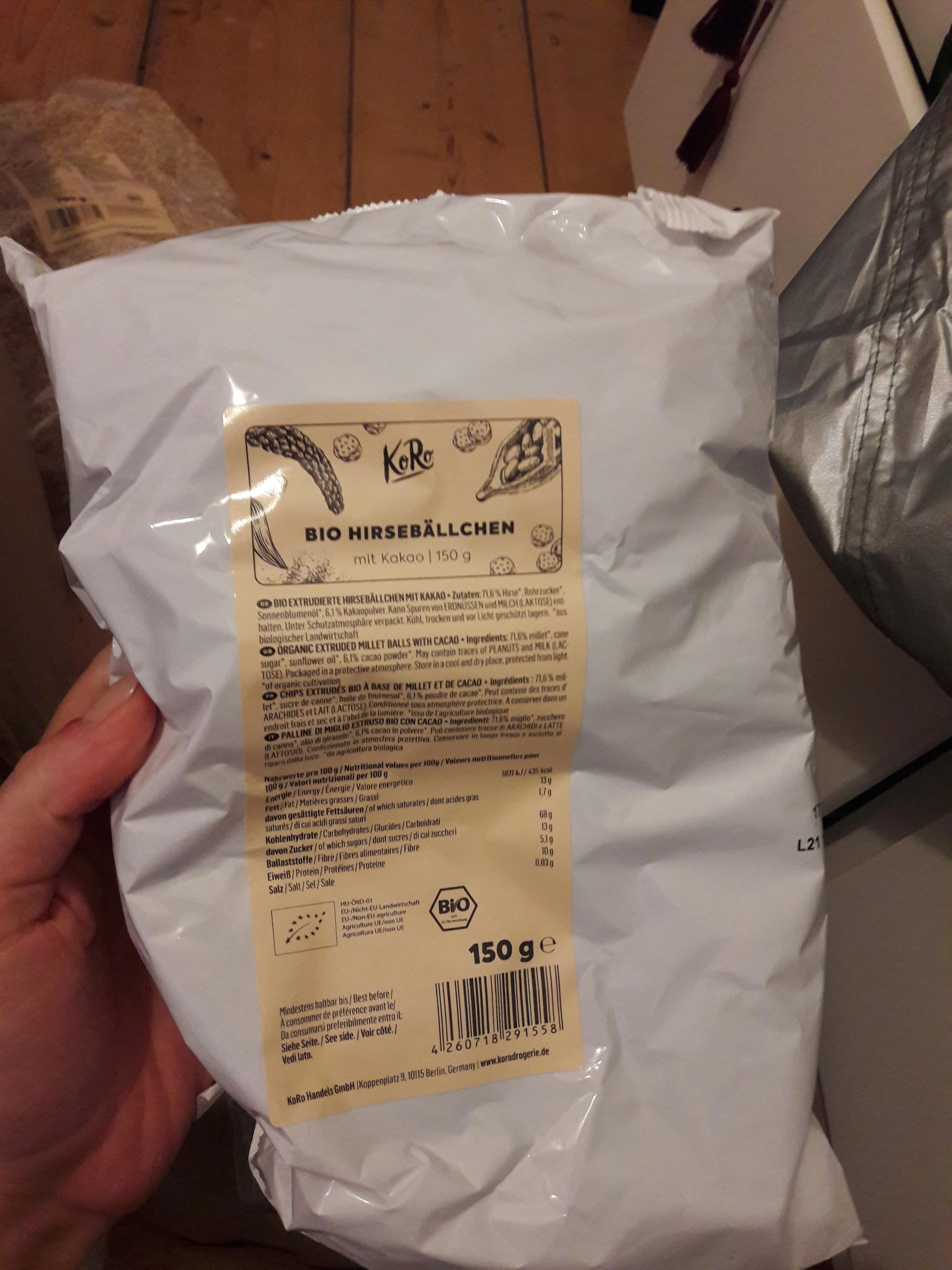 eine Person hält eine Tüte bio-Hirseballen in ihrer Hand