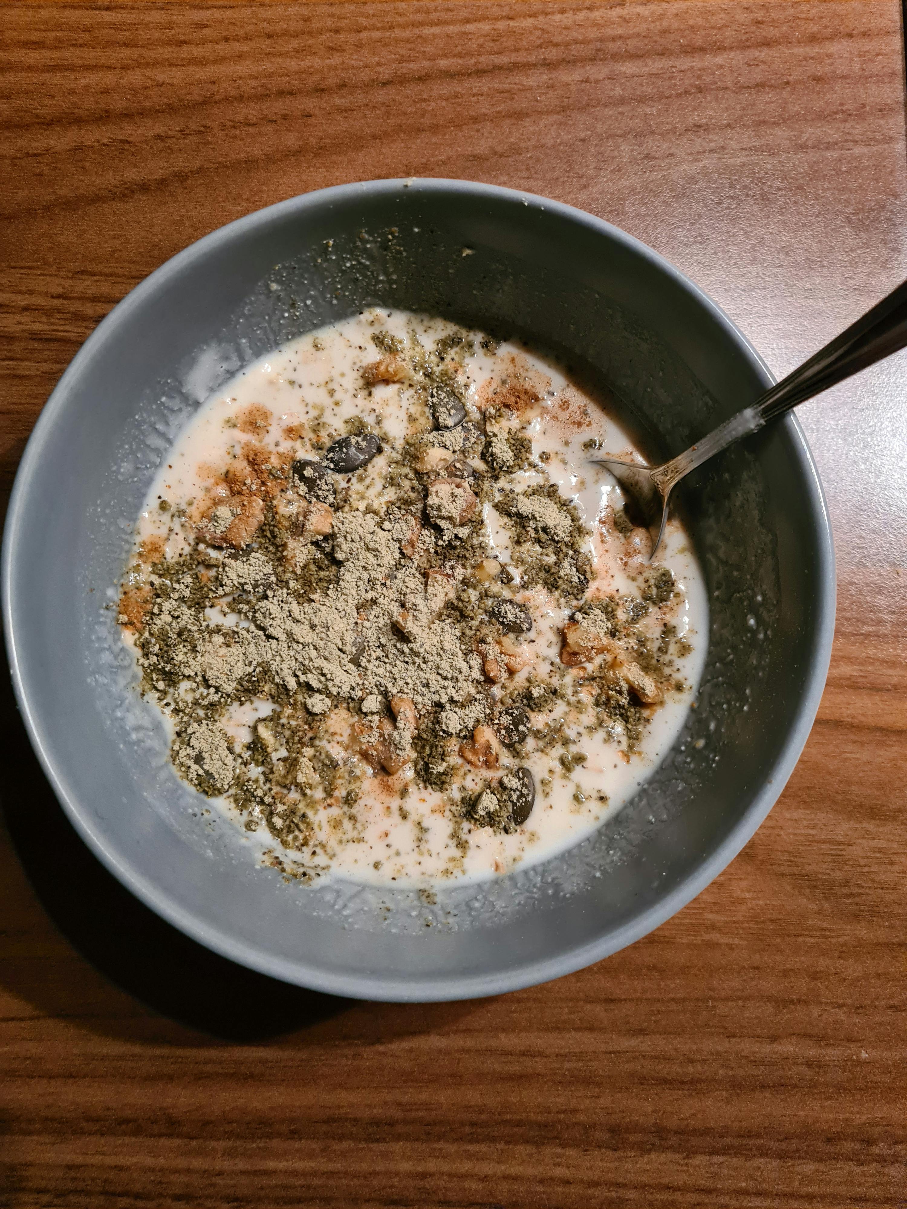 una ciotola di cereali con latte e una forchetta su un tavolo di legno