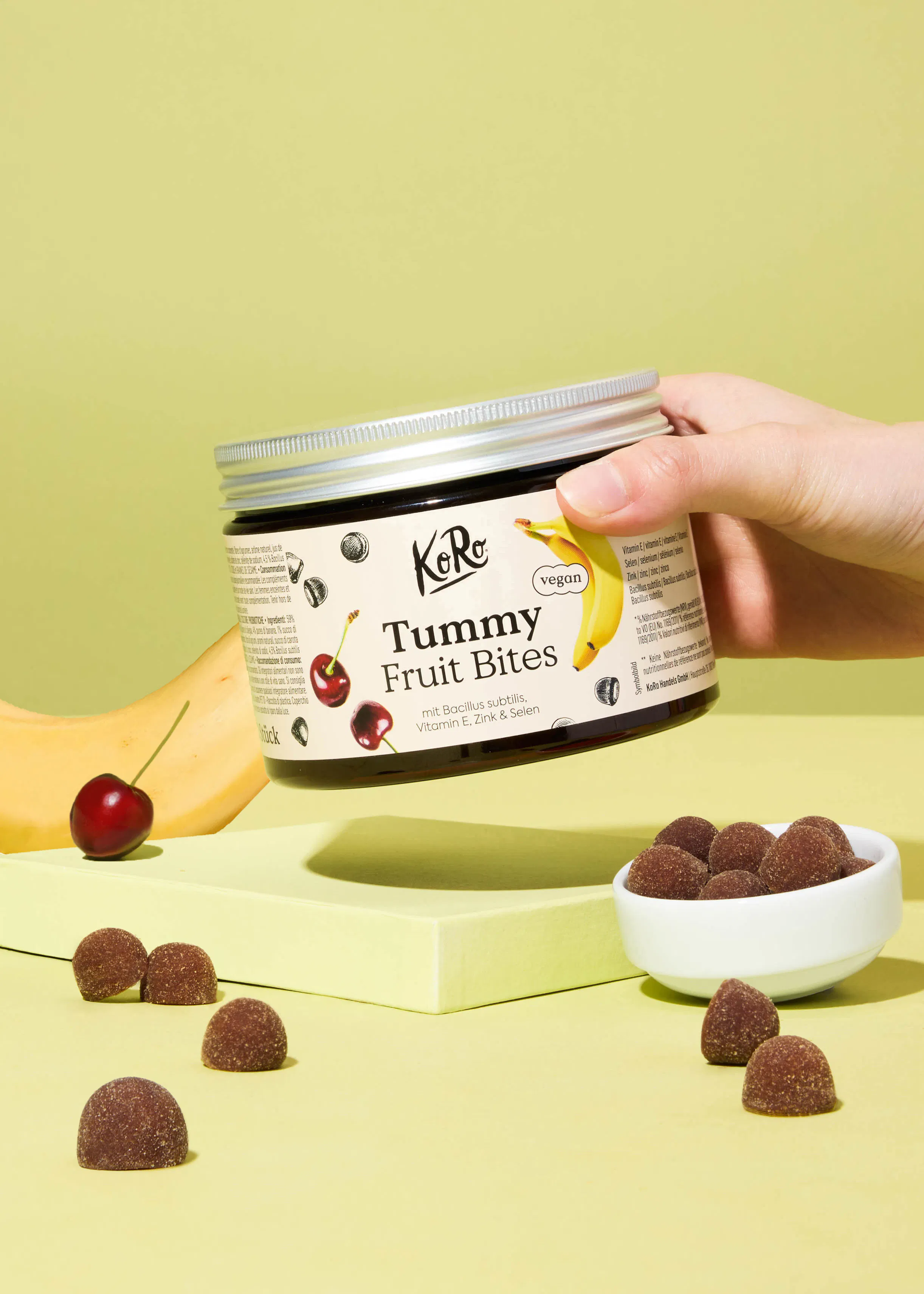 a person is holding a jar of gummy fruit bites