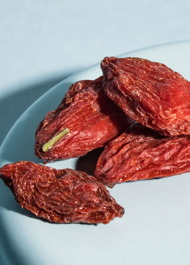 un tas de tomates séchées sur une assiette bleue