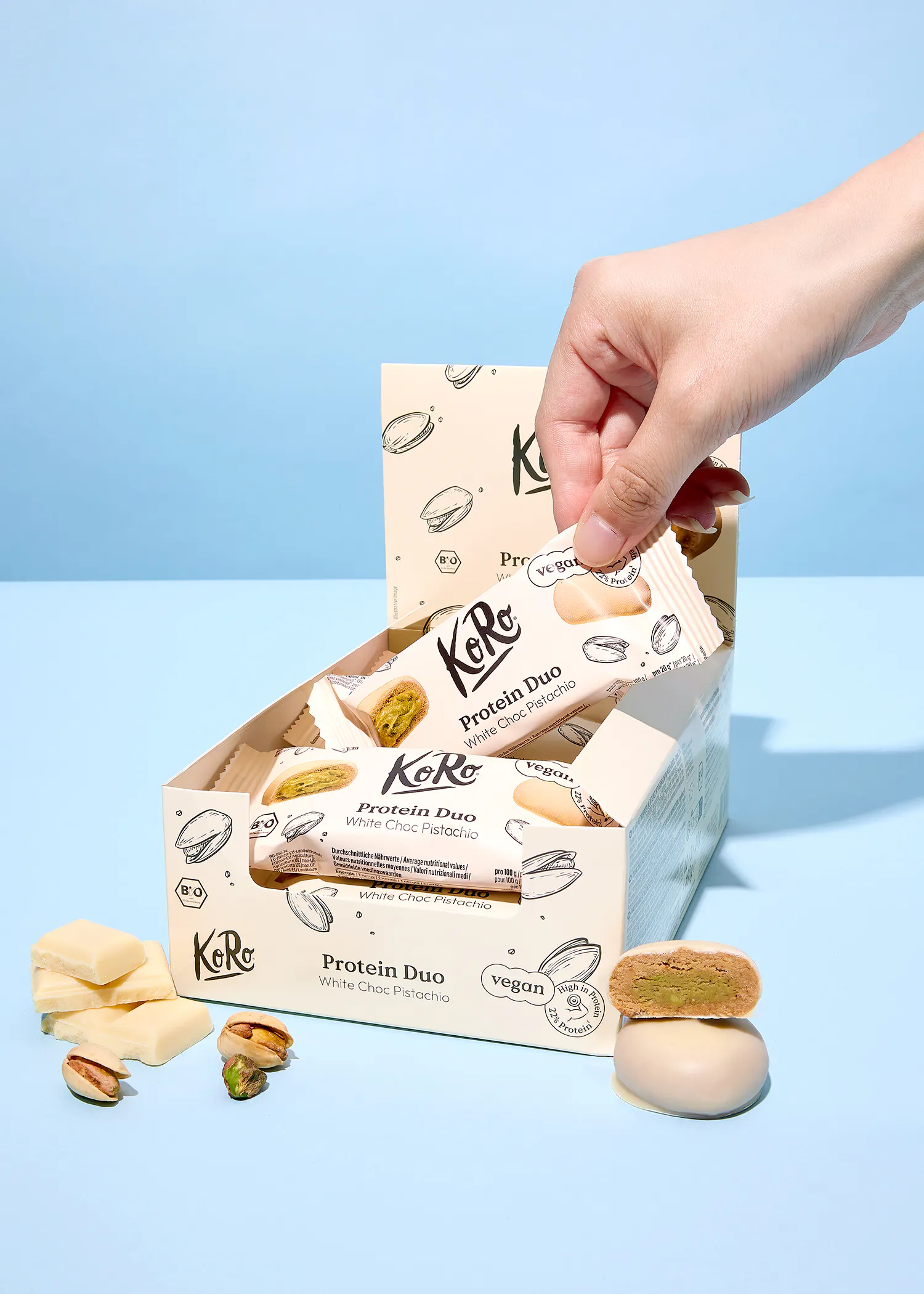 eine hand greift nach einem protein duo-getränk aus einer box