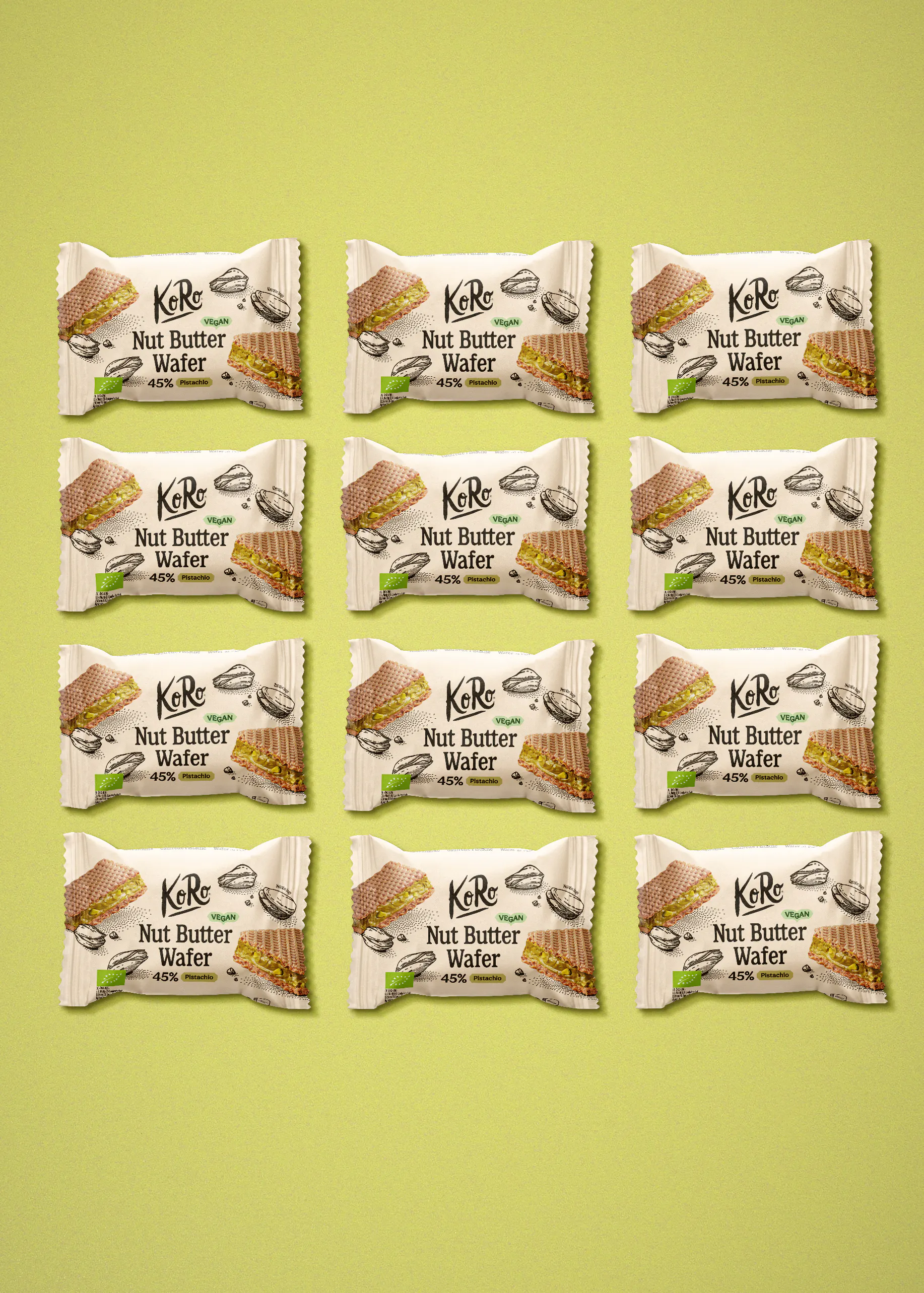 zwölf identische verpackungen der veganen koro nut butter wafer mit pistazienfüllung sind in einem raster auf hellgrünem hintergrund angeordnet.