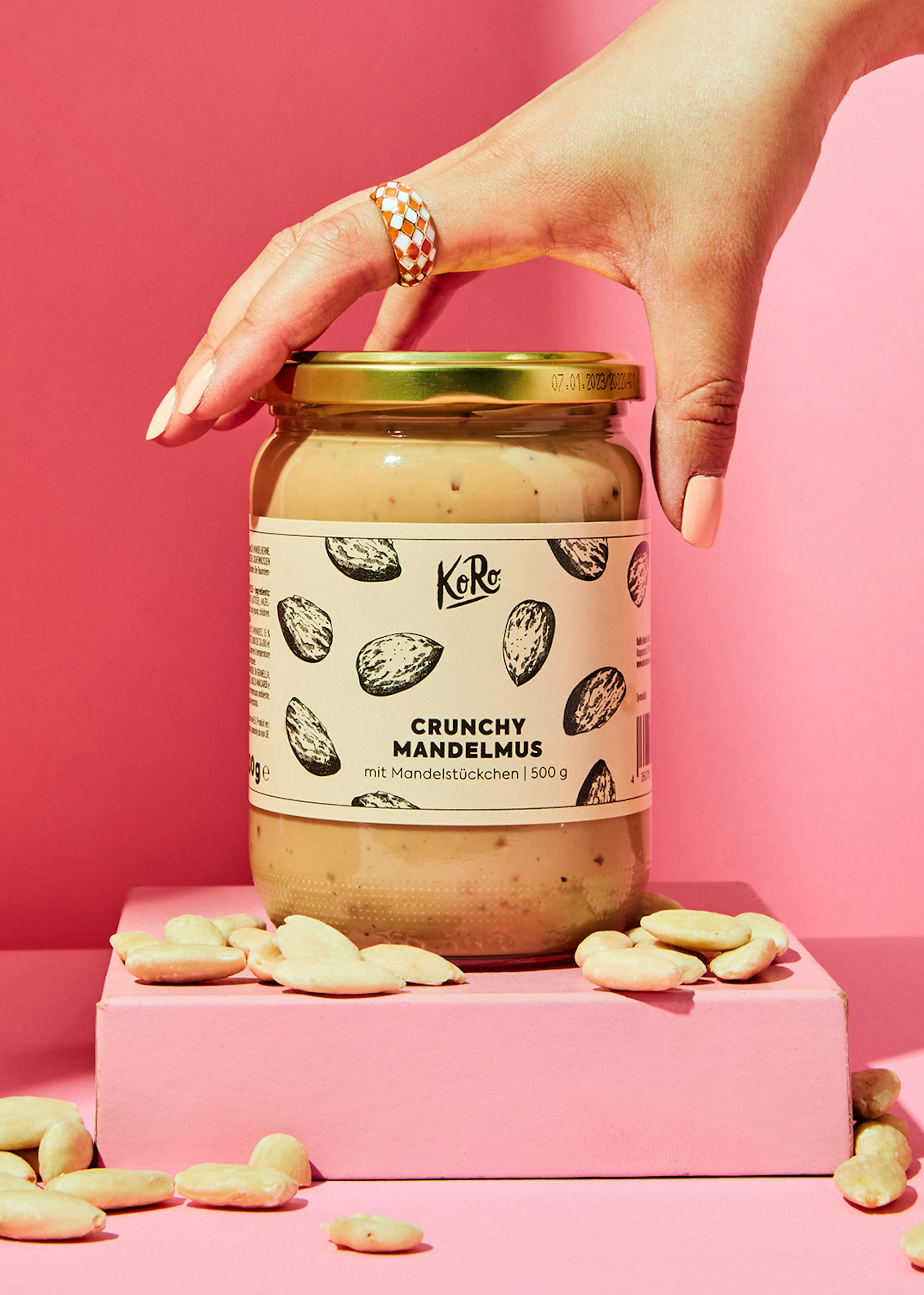 une personne tient un bocal de crunchy mandelmus