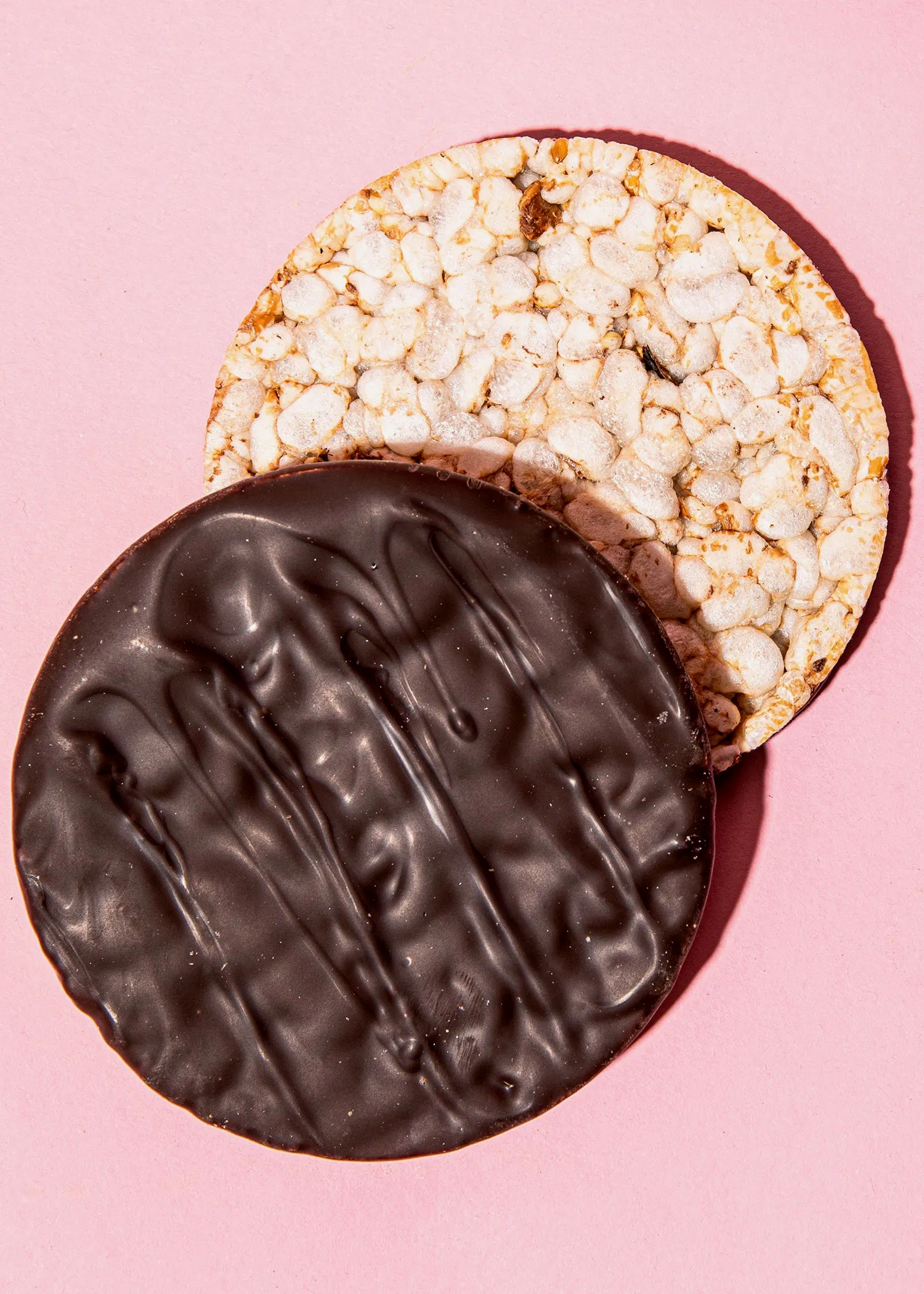 ein brauner und ein weißer Kekse auf einem rosa Hintergrund