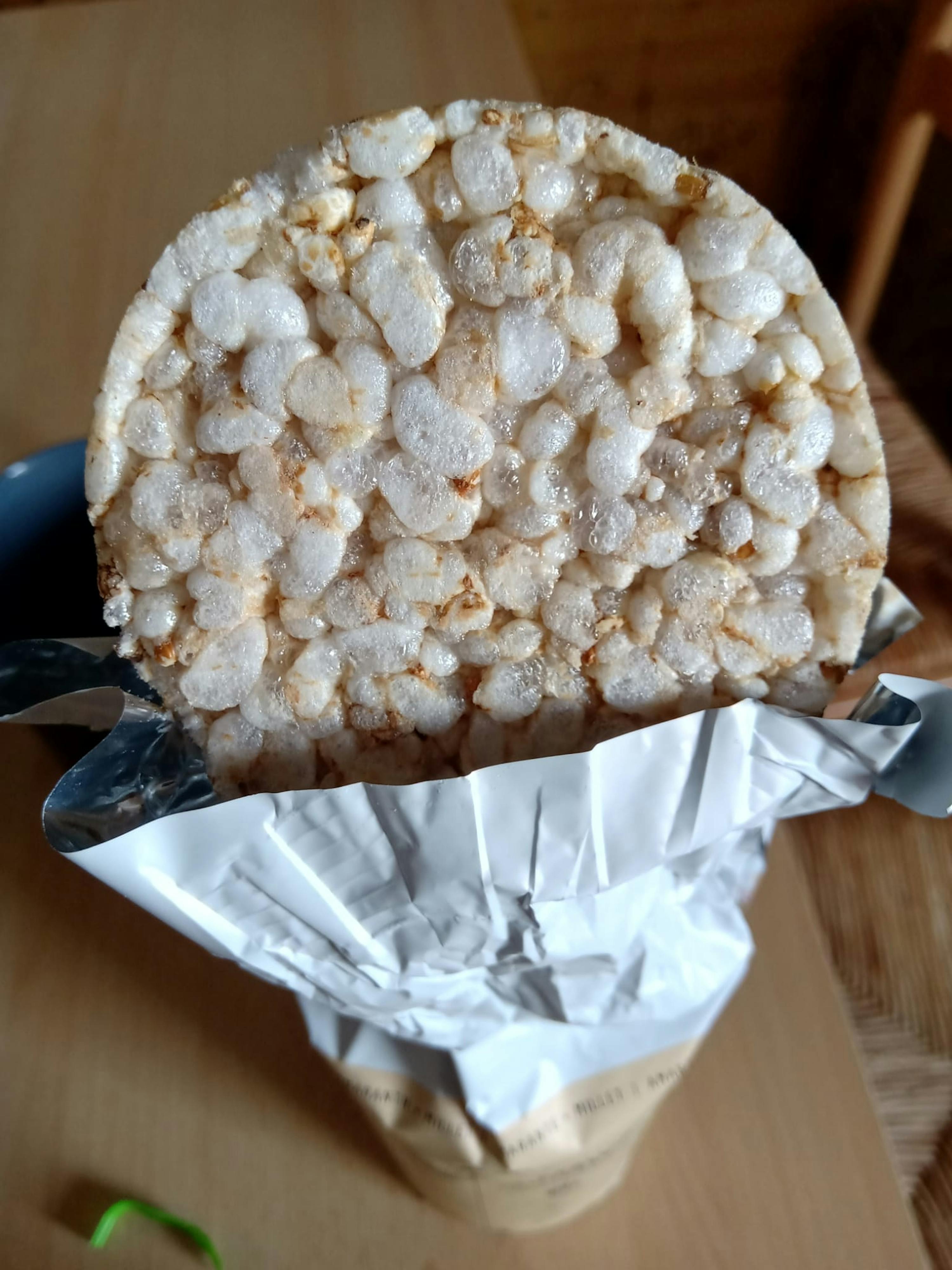 une tranche de riz soufflé est posée sur une table à côté d' un sac de riz soufflé