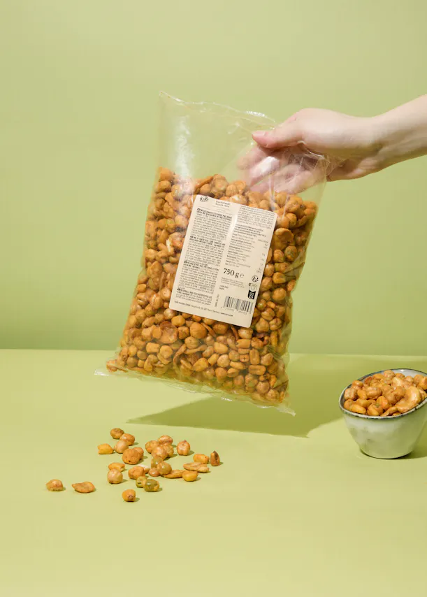 eine Person hält eine Tüte gerösteter Erdnüsse in der Hand