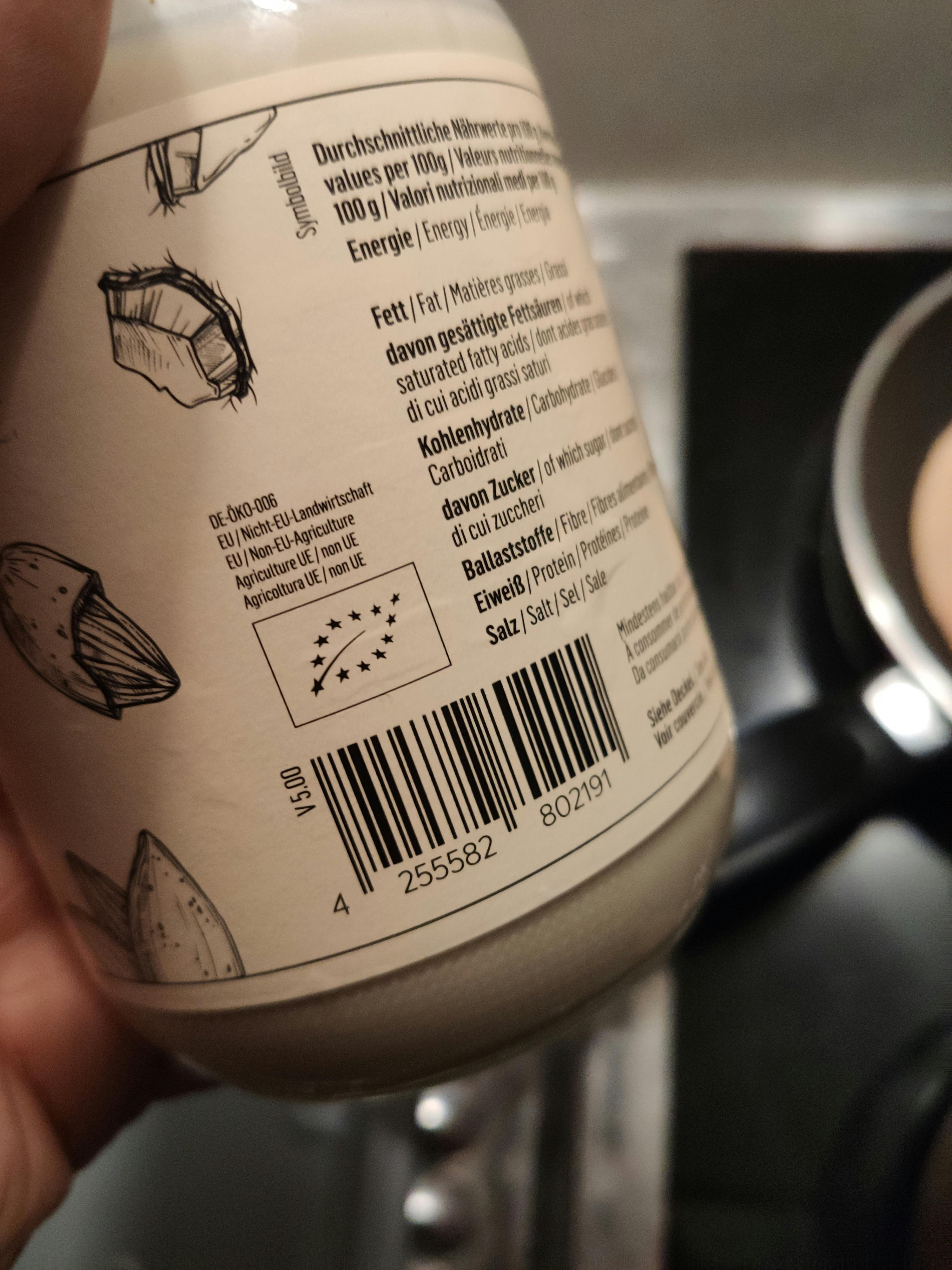 a person is holding a jar of food with a barcode on it