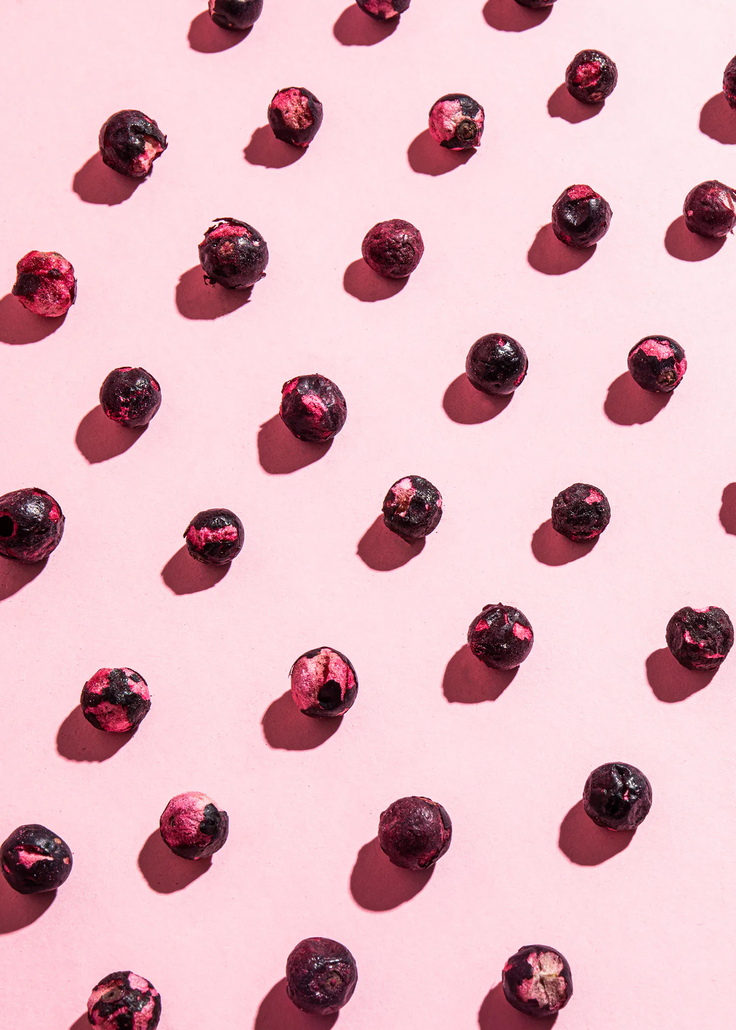 a pattern of blueberries on a pink surface
