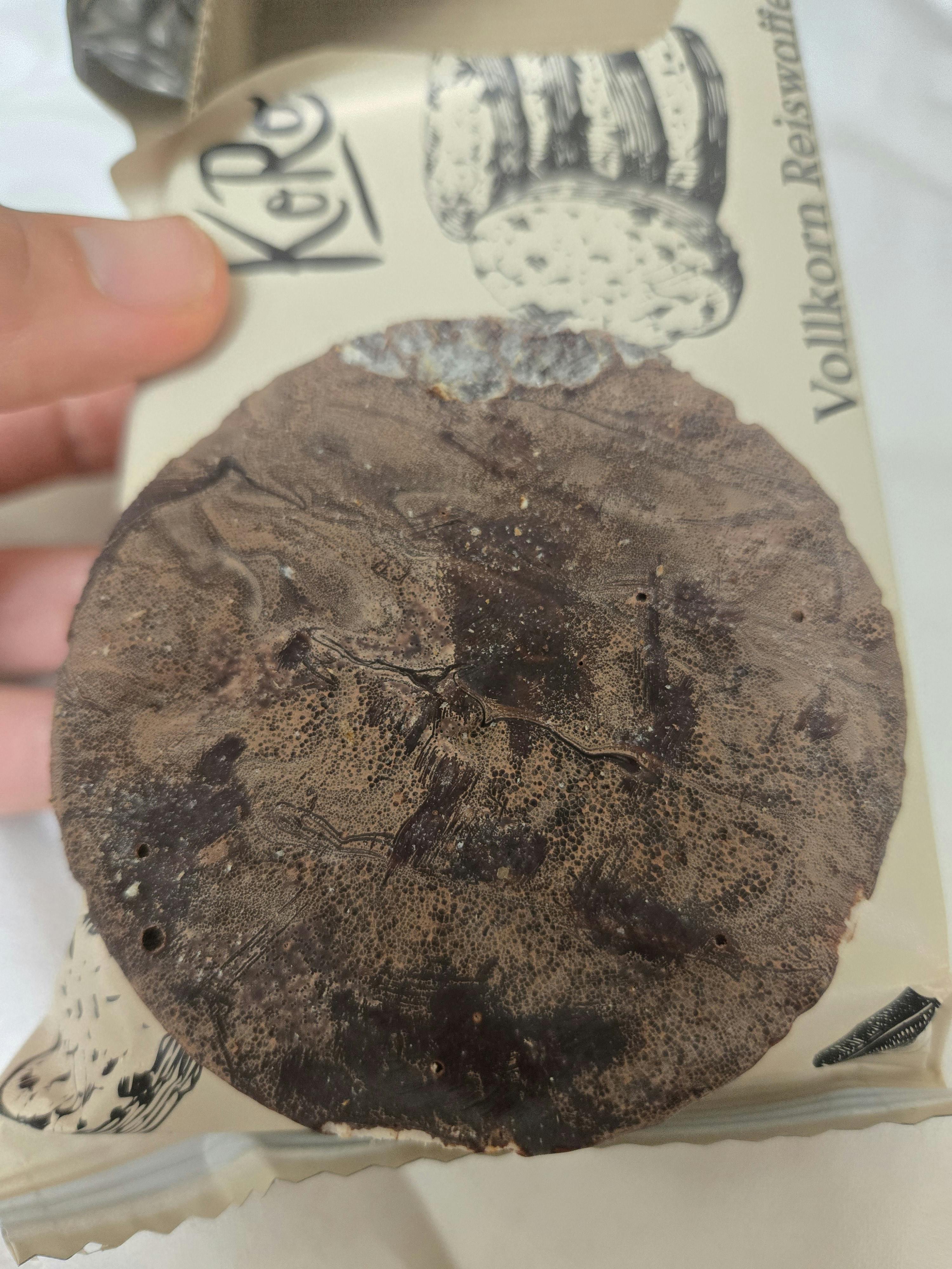 a person is holding a cookie that says vollkorn reiswaffel on it