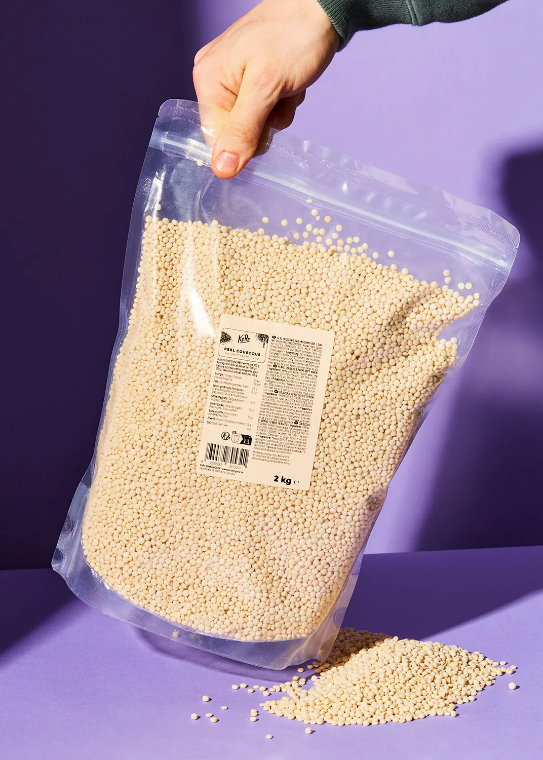 eine Person hält einen Plastikbeutel mit weißen Perlen darin