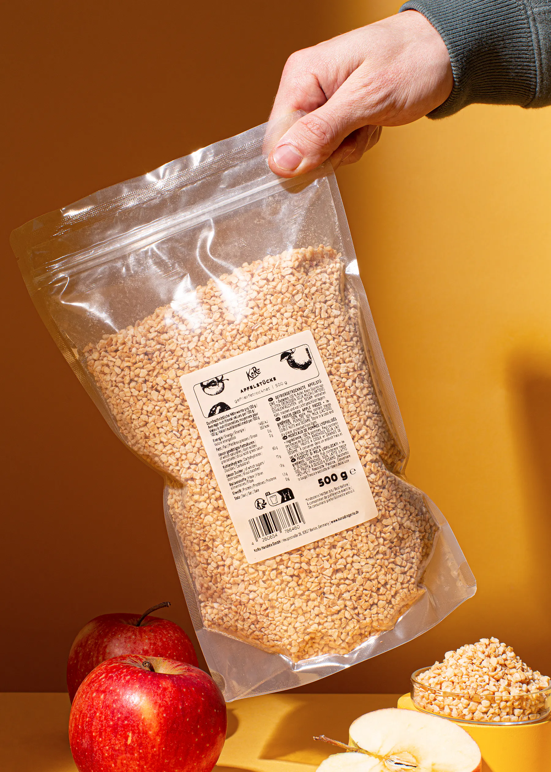 a person is holding a bag of sesame seeds in front of apples
