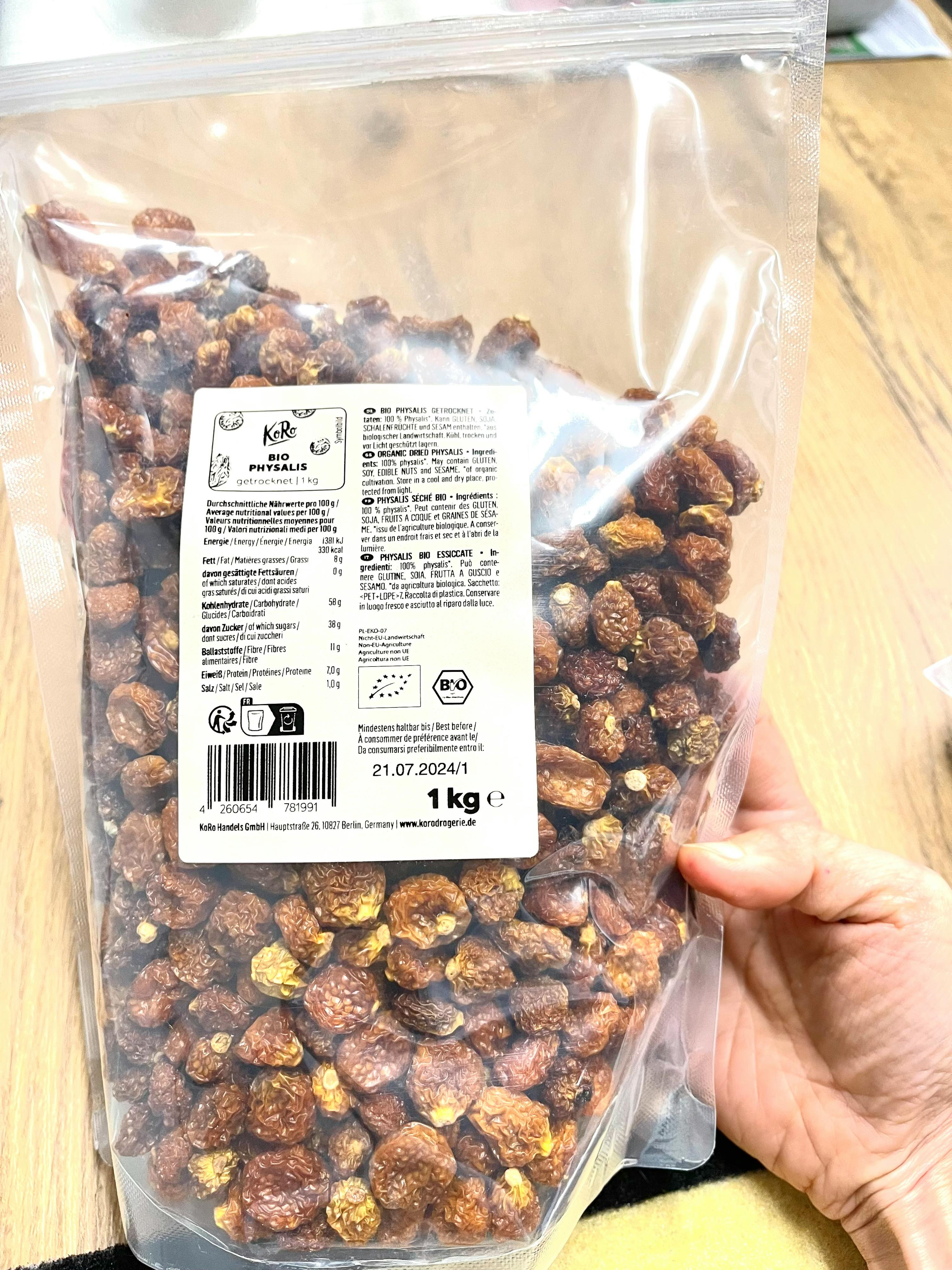 Eine Person hält einen Plastikbeutel mit Erdnüssen in der Hand