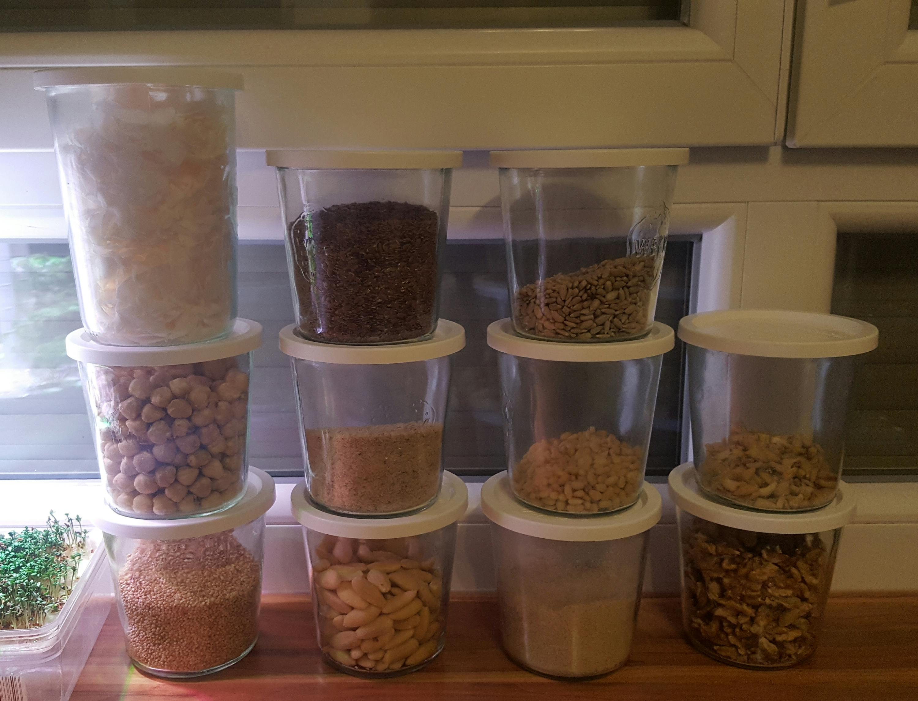 eine Reihe von Gläsern mit weißen Deckeln füllt mit verschiedenen Lebensmitteln