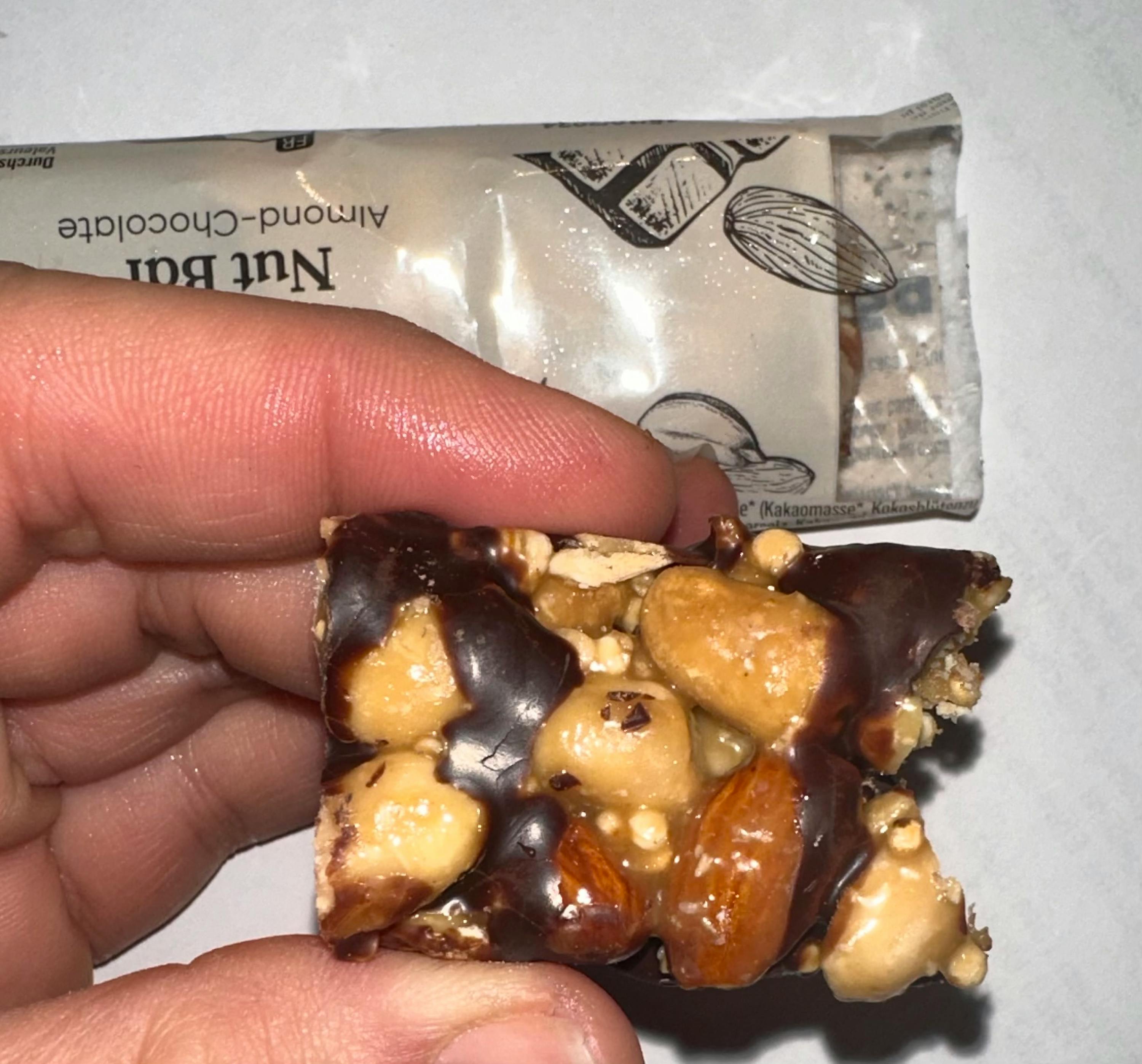 eine Person hält einen Nuss-Schokoladenriegel in der Hand