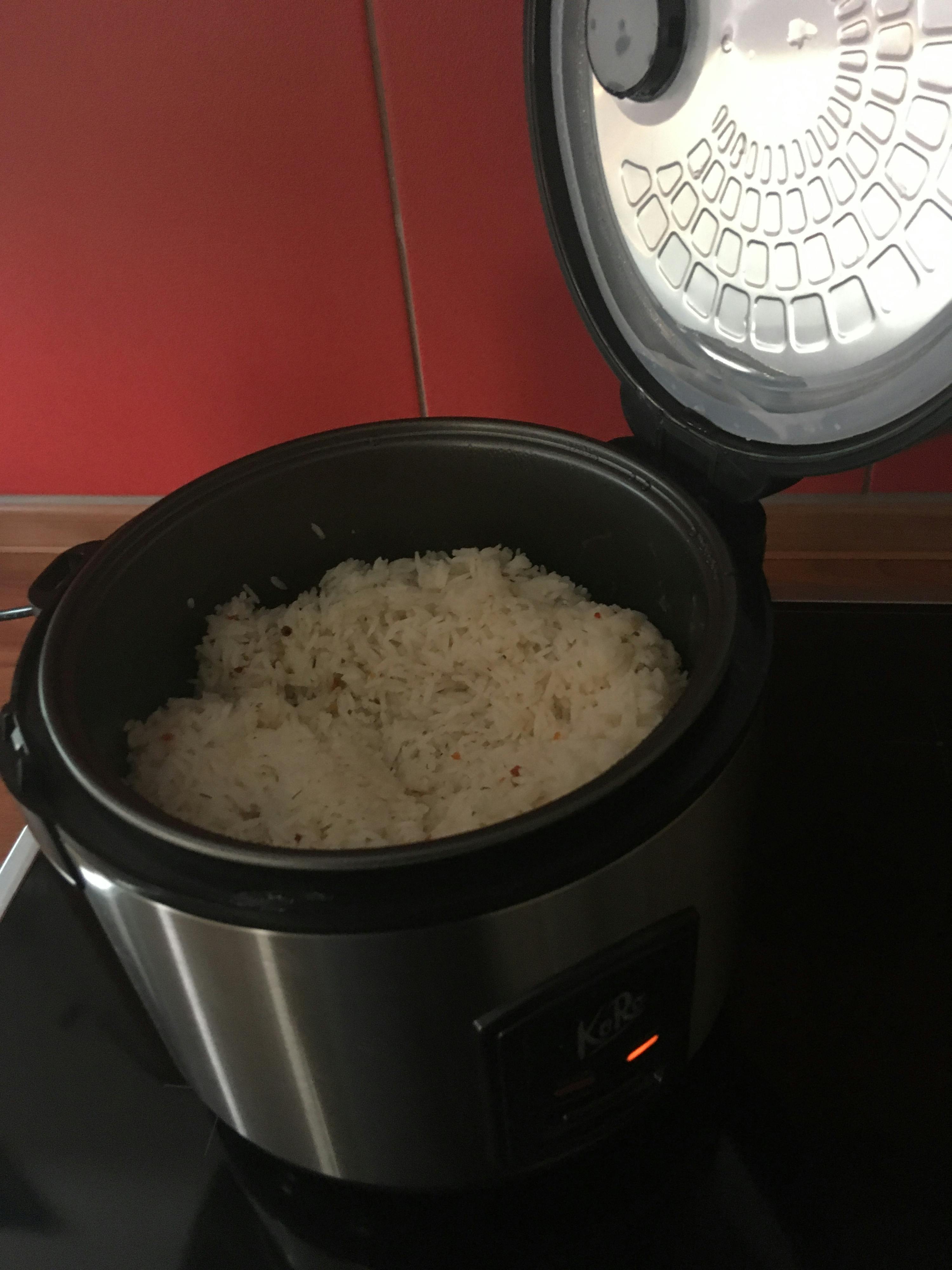 un récipient en acier inoxydable rempli de riz avec le couvercle vers le haut