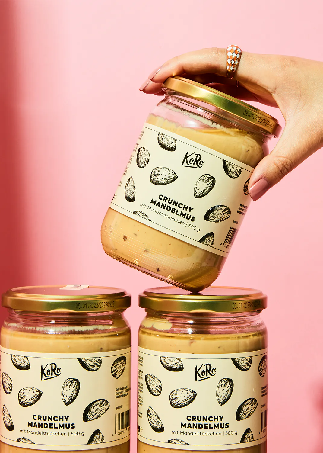 eine Person hält ein Glas crunchy Mandelmus in der Hand