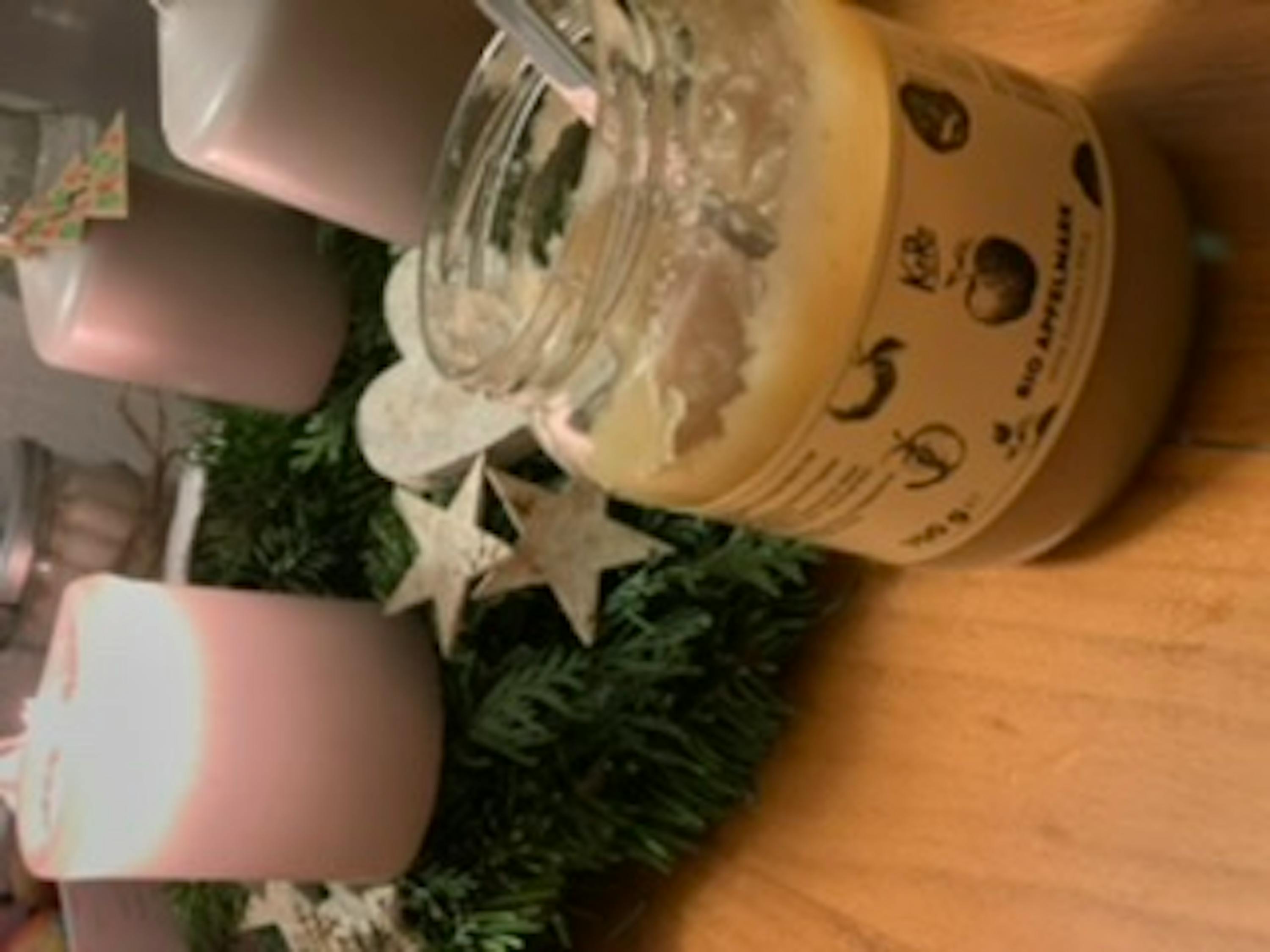 un barattolo di cibo è seduto su un tavolo accanto a candele