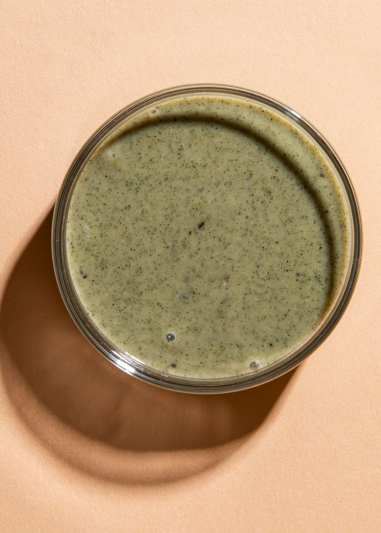 a close up of a bowl of green liquid on a table