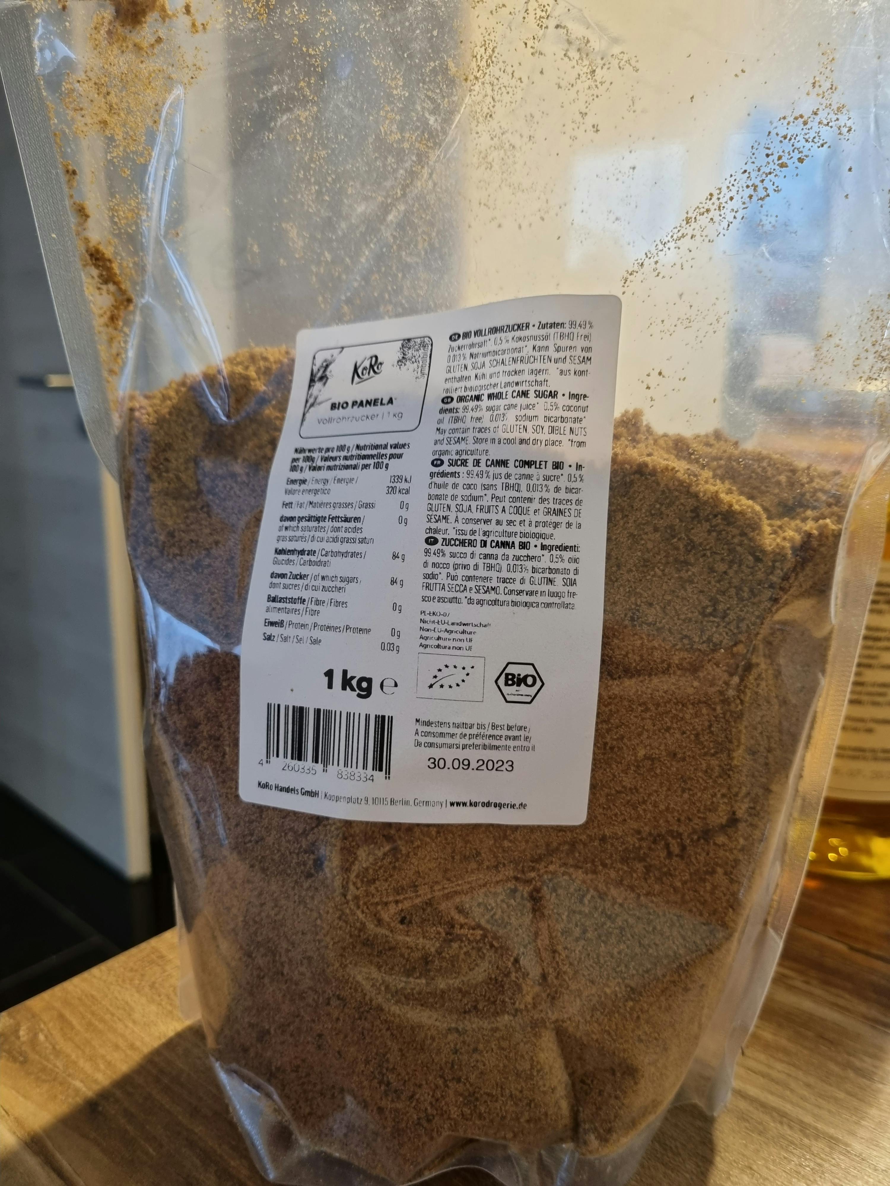 un sacchetto di zucchero marrone è seduto su un tavolo di legno