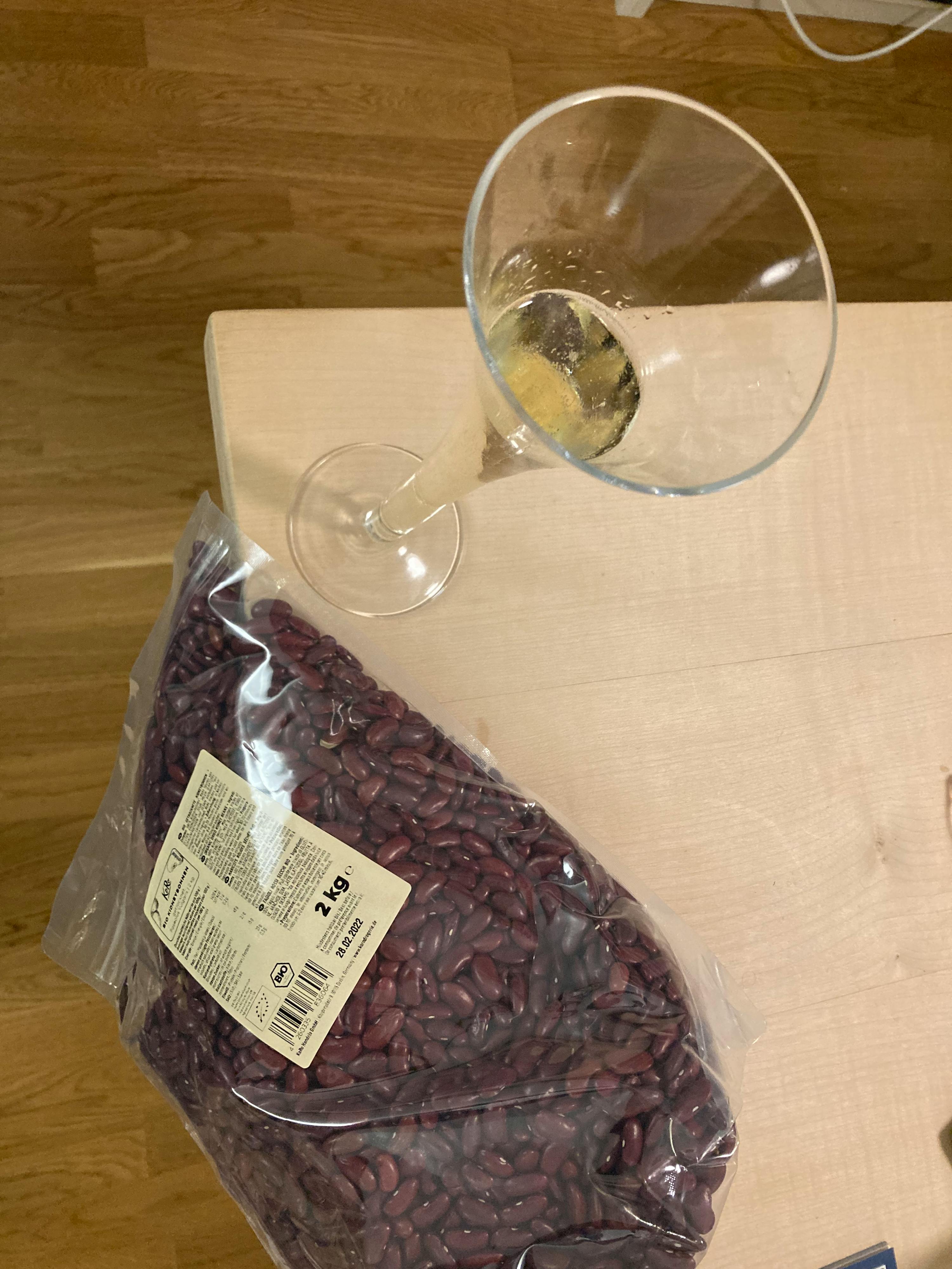 a bag of red beans sits on a table next to a glass