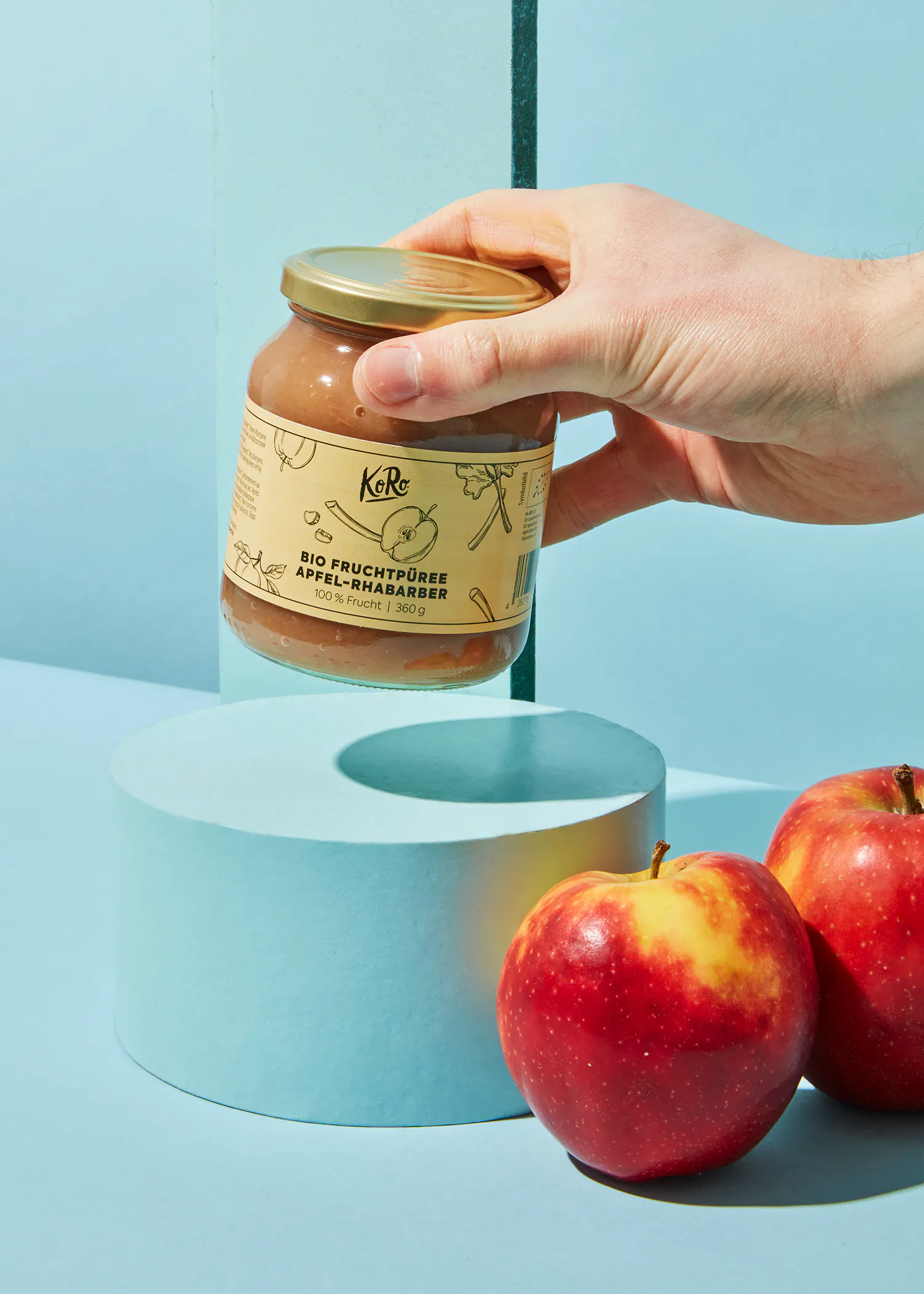 eine Person hält ein Glas Apfel-Rhubarb-Sauce in der Hand